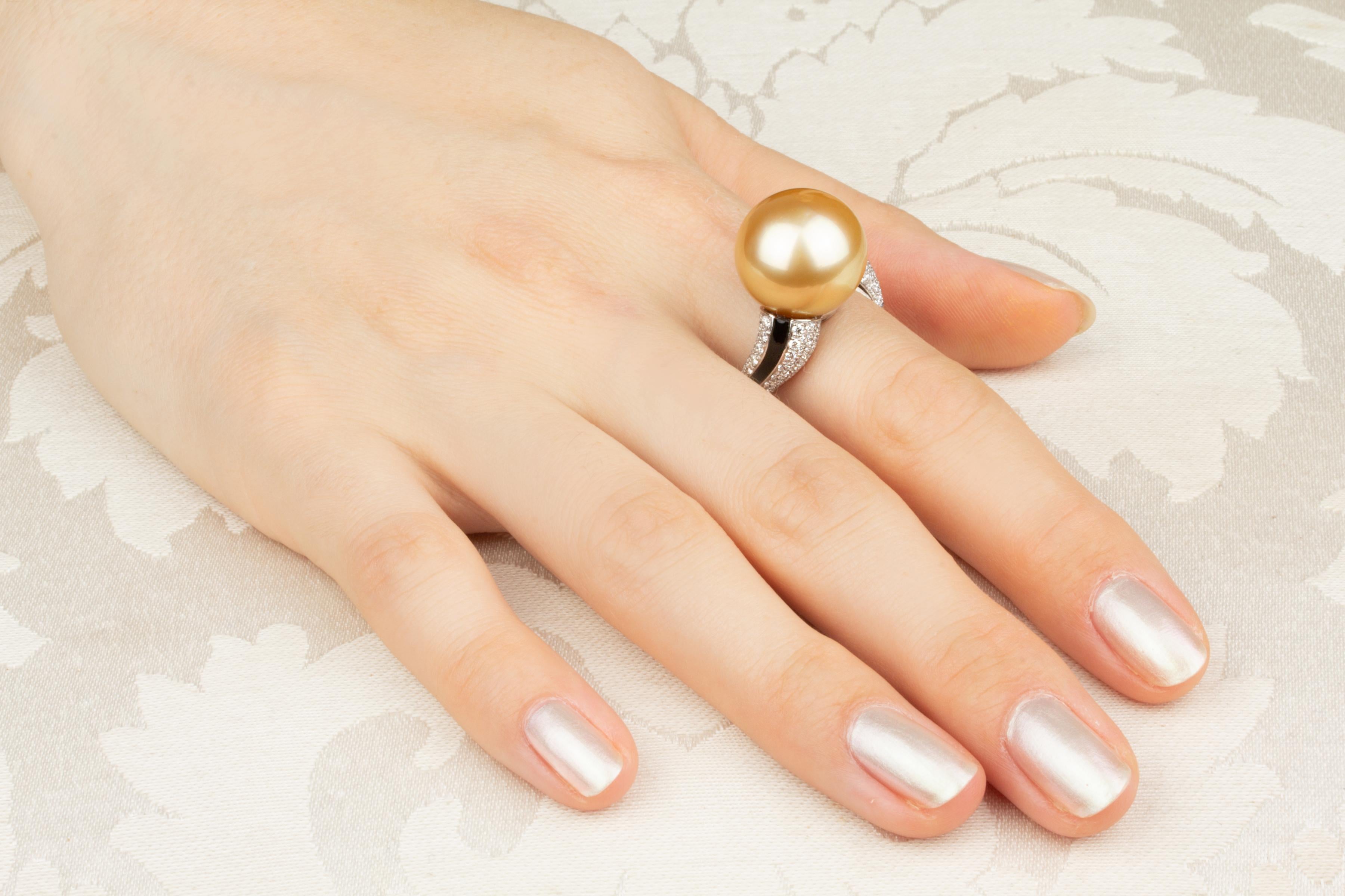 This golden pearl and diamond ring features a splendid pearl of 15.5/16mm diameter. The pearl is untreated. It displays fine nacre and its natural color and luster have not been enhanced in any way. The pearl is flanked by custom cut black onyx
