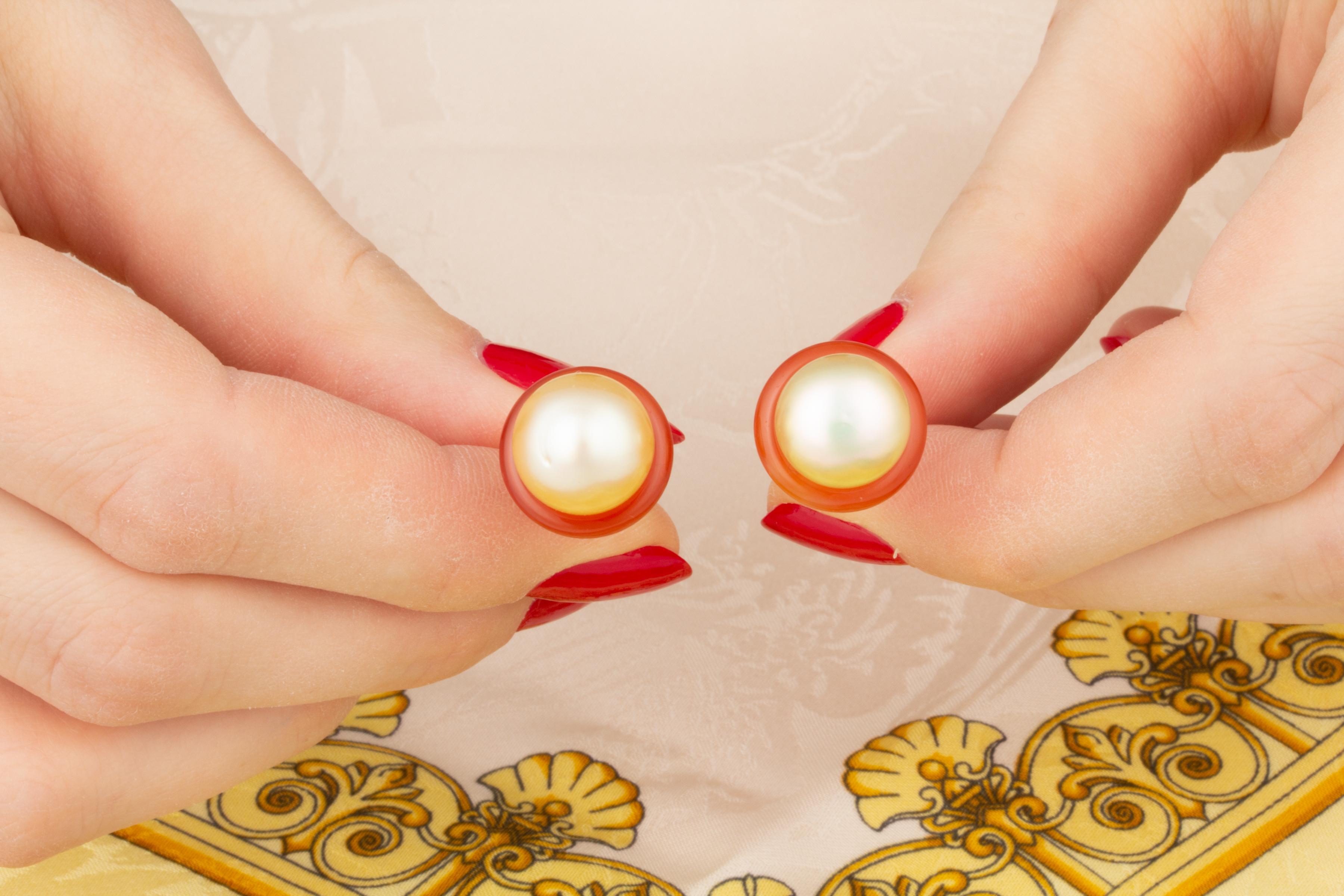 Die Manschettenknöpfe für Damen sind mit zwei glänzenden Perlen von 11 mm Durchmesser versehen. Sie sind von einer Krone aus geschliffenem Jadeit umgeben. 
Alle unsere Perlen sind unbehandelt: Ihre natürliche Farbe und ihr hoher Glanz wurden in