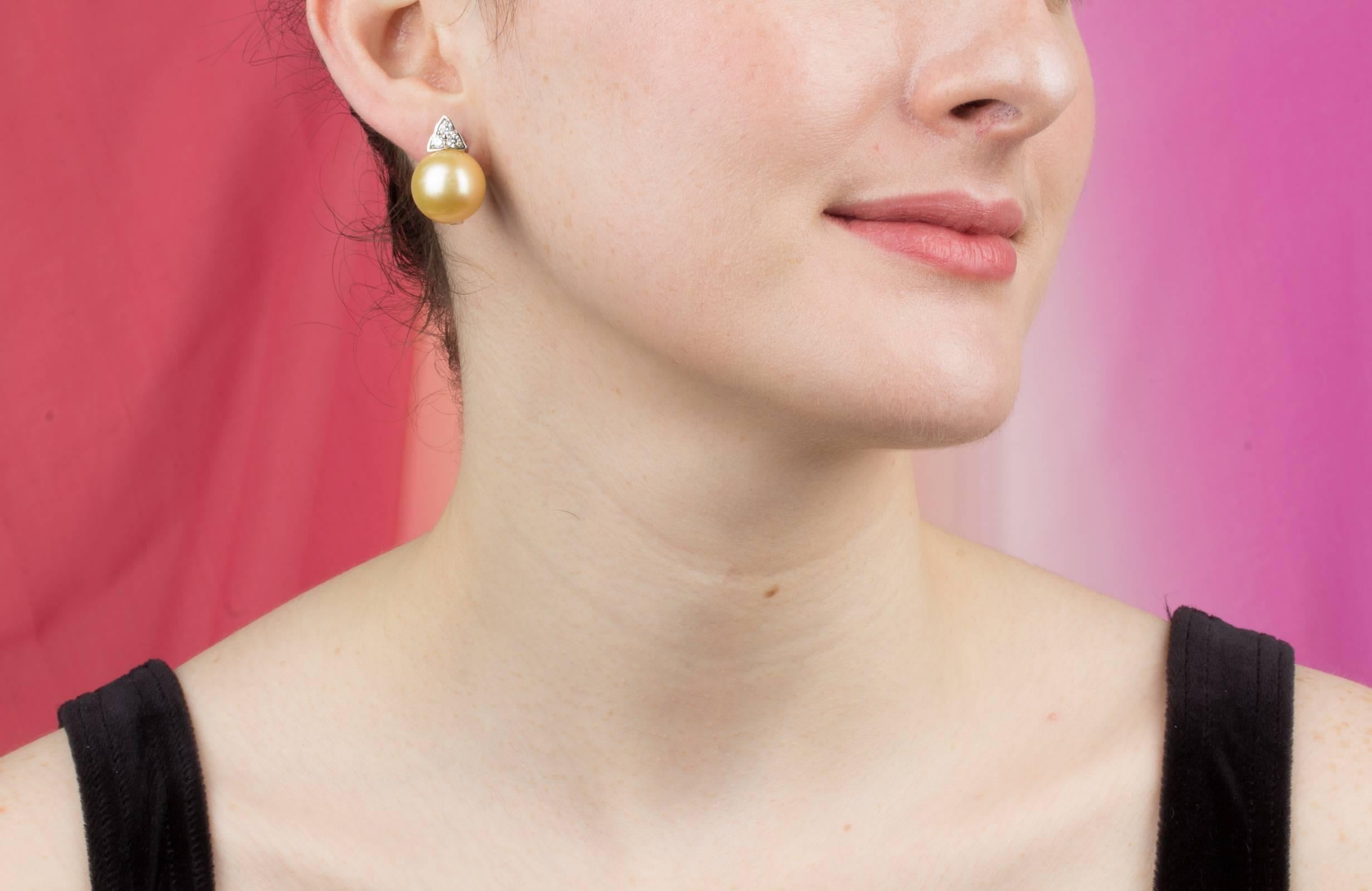 The golden pearl and diamond earrings feature two large South Sea pearls of 16mm diameter with a decorative triangular diamond design.
The untreated South Sea pearls originate from the waters of Northwestern Australia. They display a lovely nacre