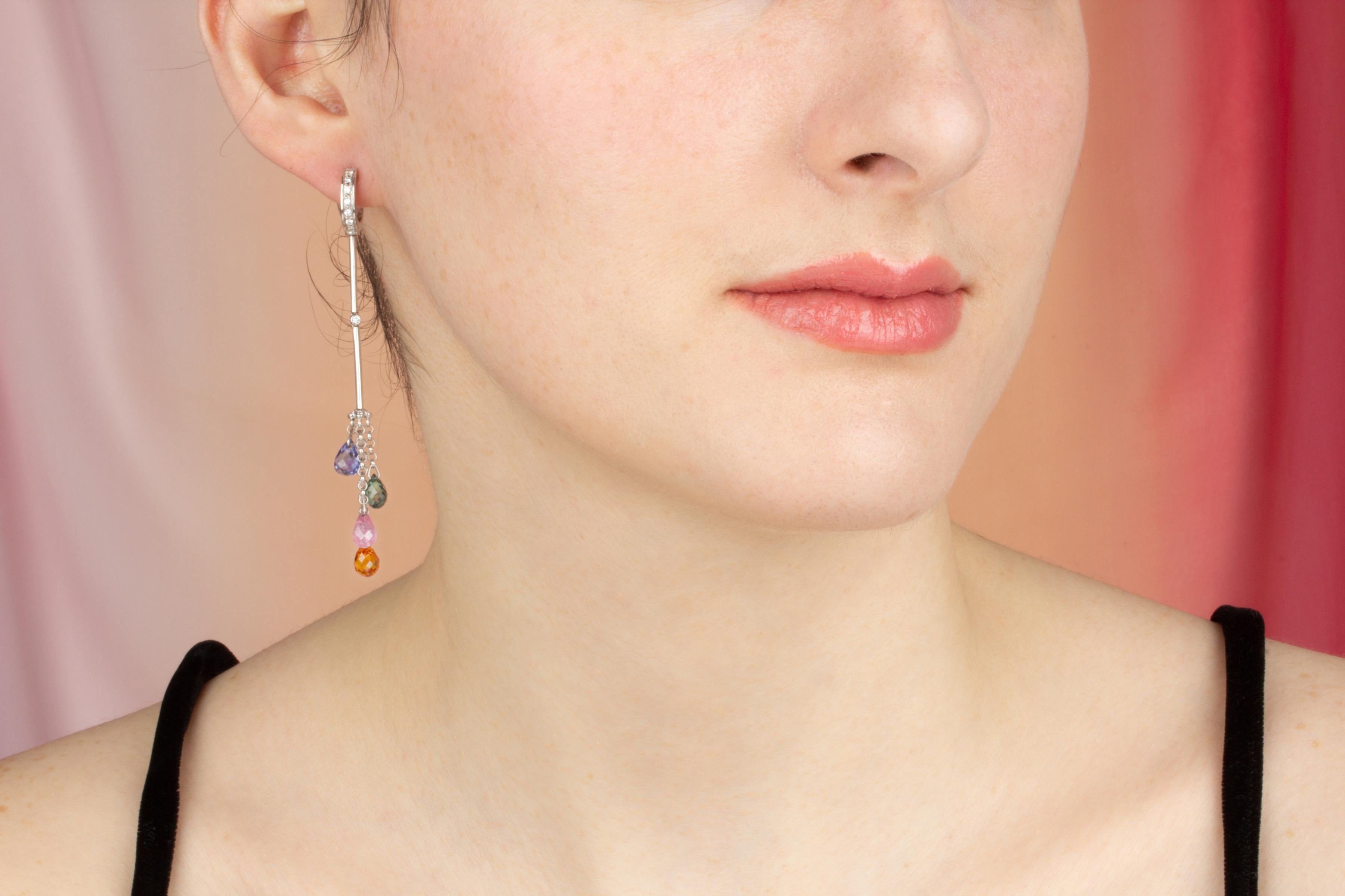 The sapphire drop earrings feature 8 briolette sapphires of different different colors for a total of approximately 11 carats in a playful and flexible design. The earring is complete with 0.30 carats of round diamonds of top quality (G/V-VVS,