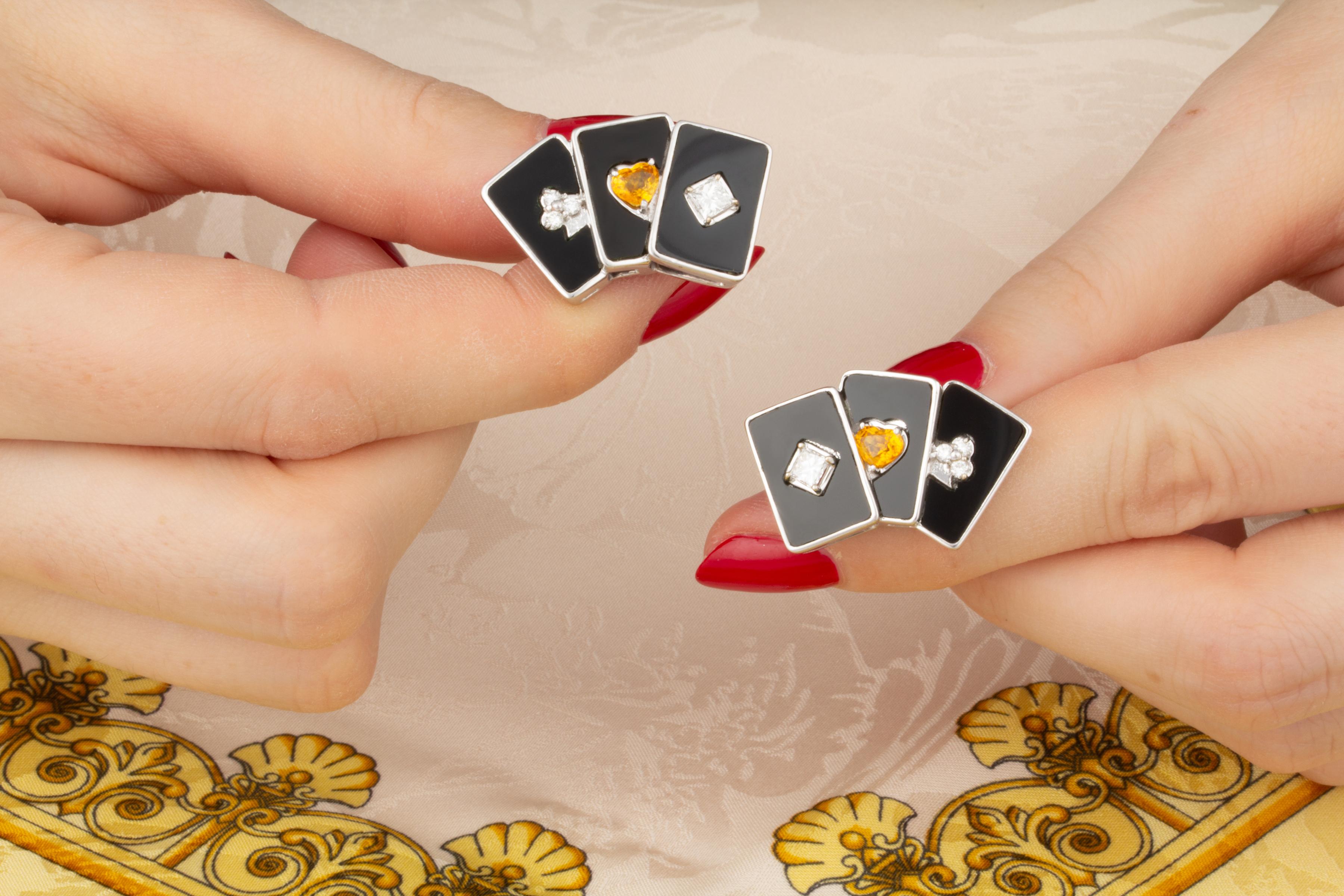 Die Manschettenknöpfe mit Spielkarten bestehen aus Diamanten und gelben Saphiren in Herzform, die in einen speziell geschliffenen schwarzen Onyx in einer Weißgoldfassung gefasst sind, was dem Schmuckstück einen unverwechselbaren Art-Déco-Look