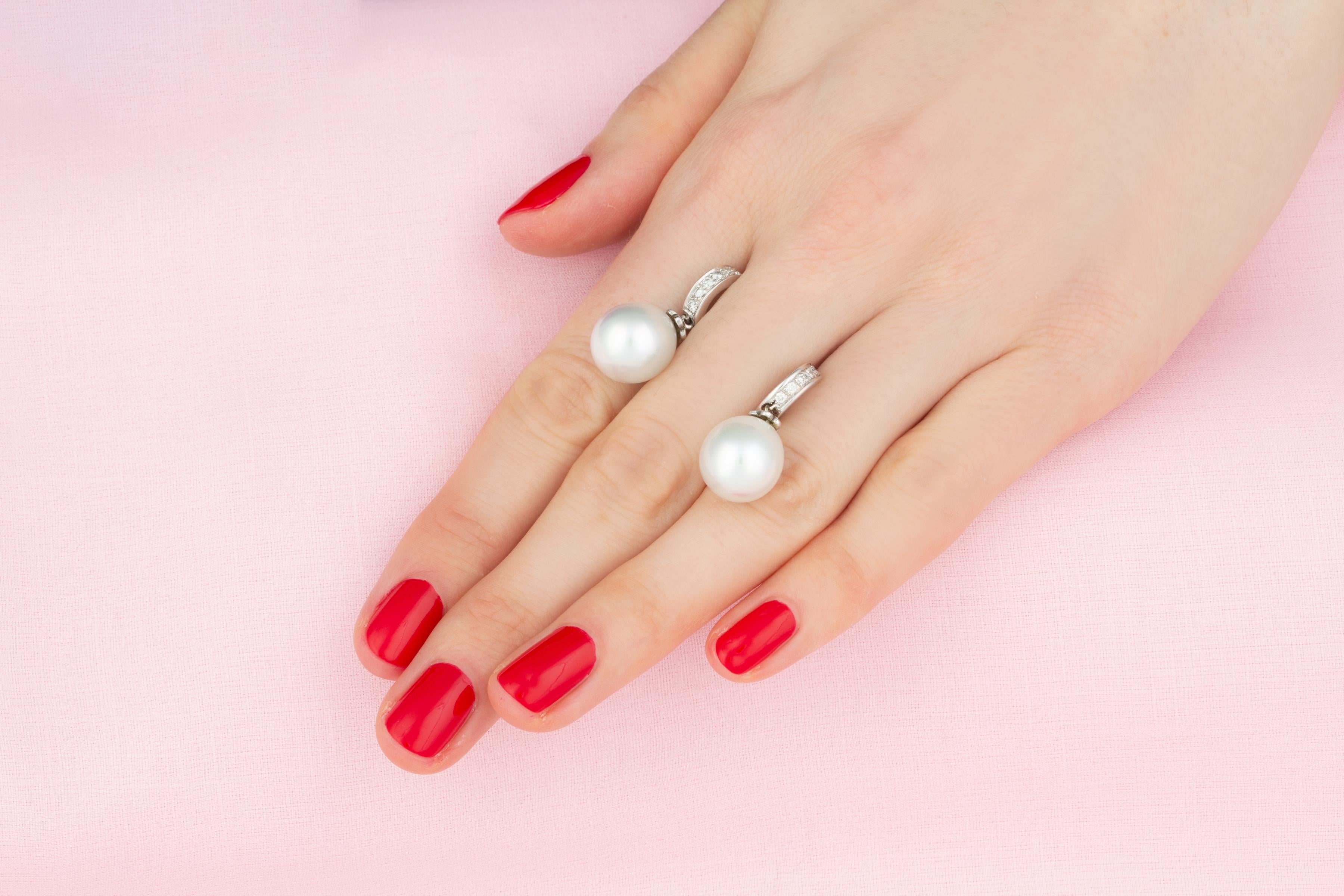 Les boucles d'oreilles pendantes en perles des mers du Sud et diamants sont composées de deux perles de 12 mm de diamètre, d'une belle qualité de nacre et d'un éclat magnifique.
Les perles sont suspendues à deux anneaux sertis de diamants ronds de