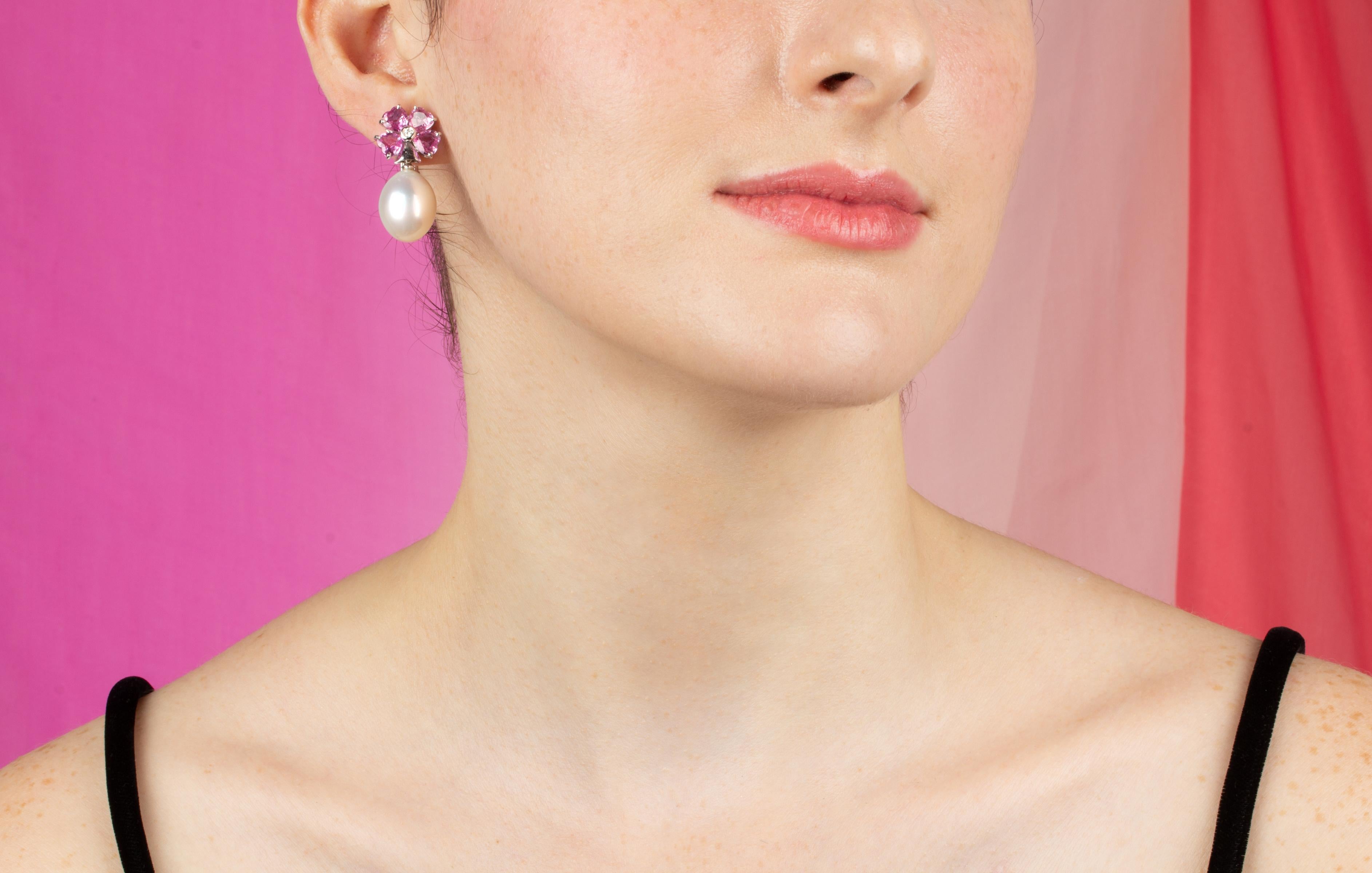 The South Sea pearl earrings feature a flower design on the ear with 6.82 carats of heart shaped pink sapphires. The tops suspend 2 South Sea pearls of 13 x16mm diameter. 0.12 carats of round diamonds complete the design.
All of our pearls are
