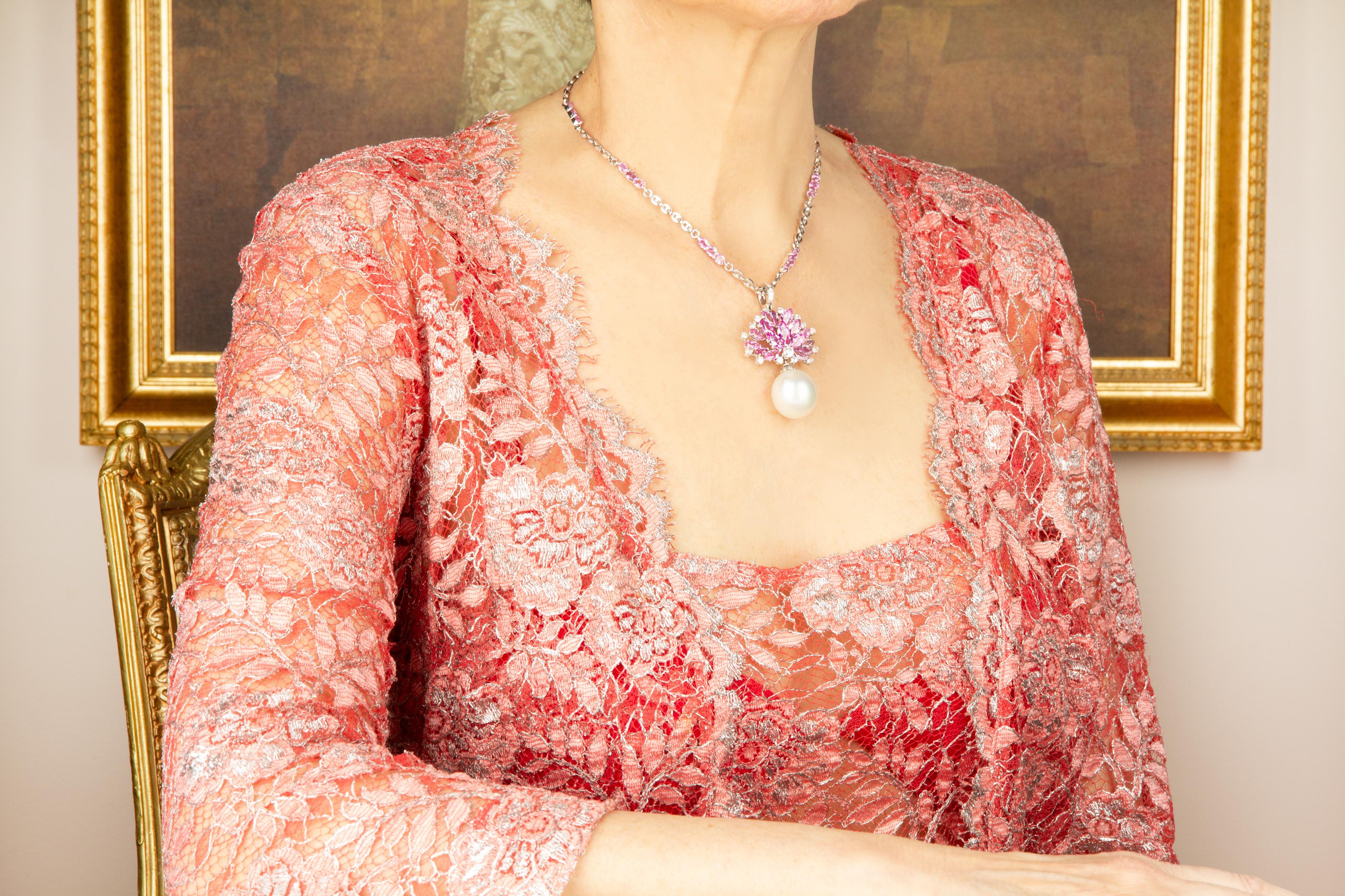 The pink sapphire pendant features a spray of marquise shape faceted sapphires spangled with round diamonds. The jewel suspends a splendid South Sea pearl of extraordinary size: 20 x 18mm. The 2” pendant is accompanied by a 14” chain decorated with