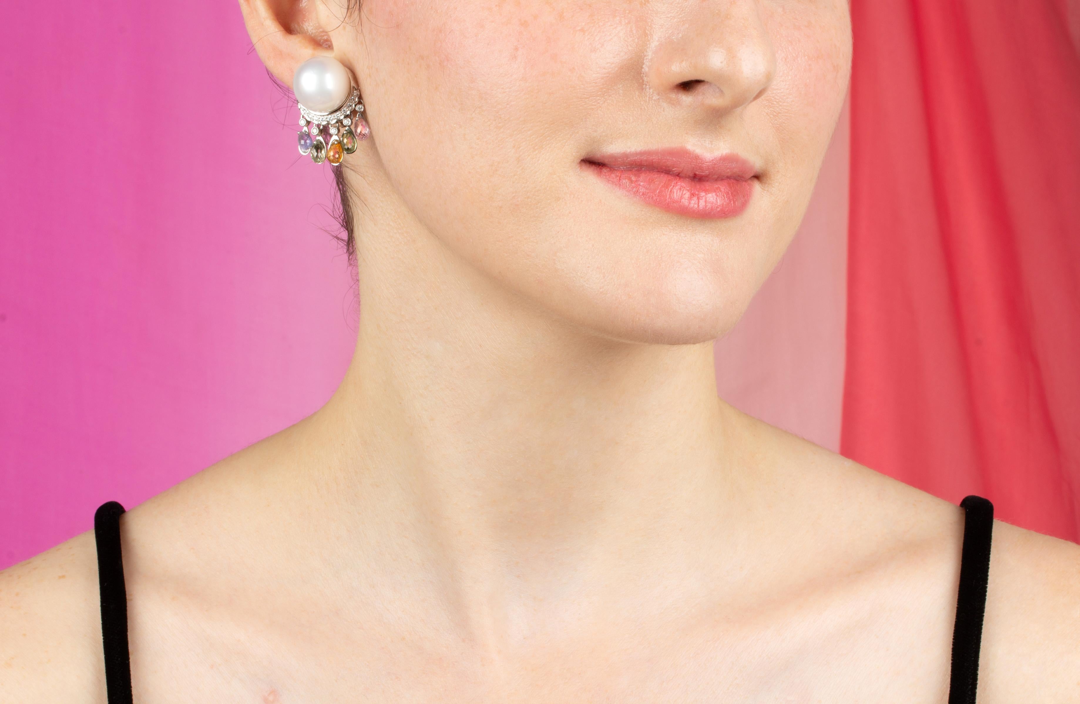 The South Sea pearl and sapphire earrings feature a pair of fine, homogeneous South Sea pearls of 15.5mm diameter. The pearls are perched on a crown of round diamonds (0.80 carats) suspending 10 sapphire briolettes of different colors (approximately