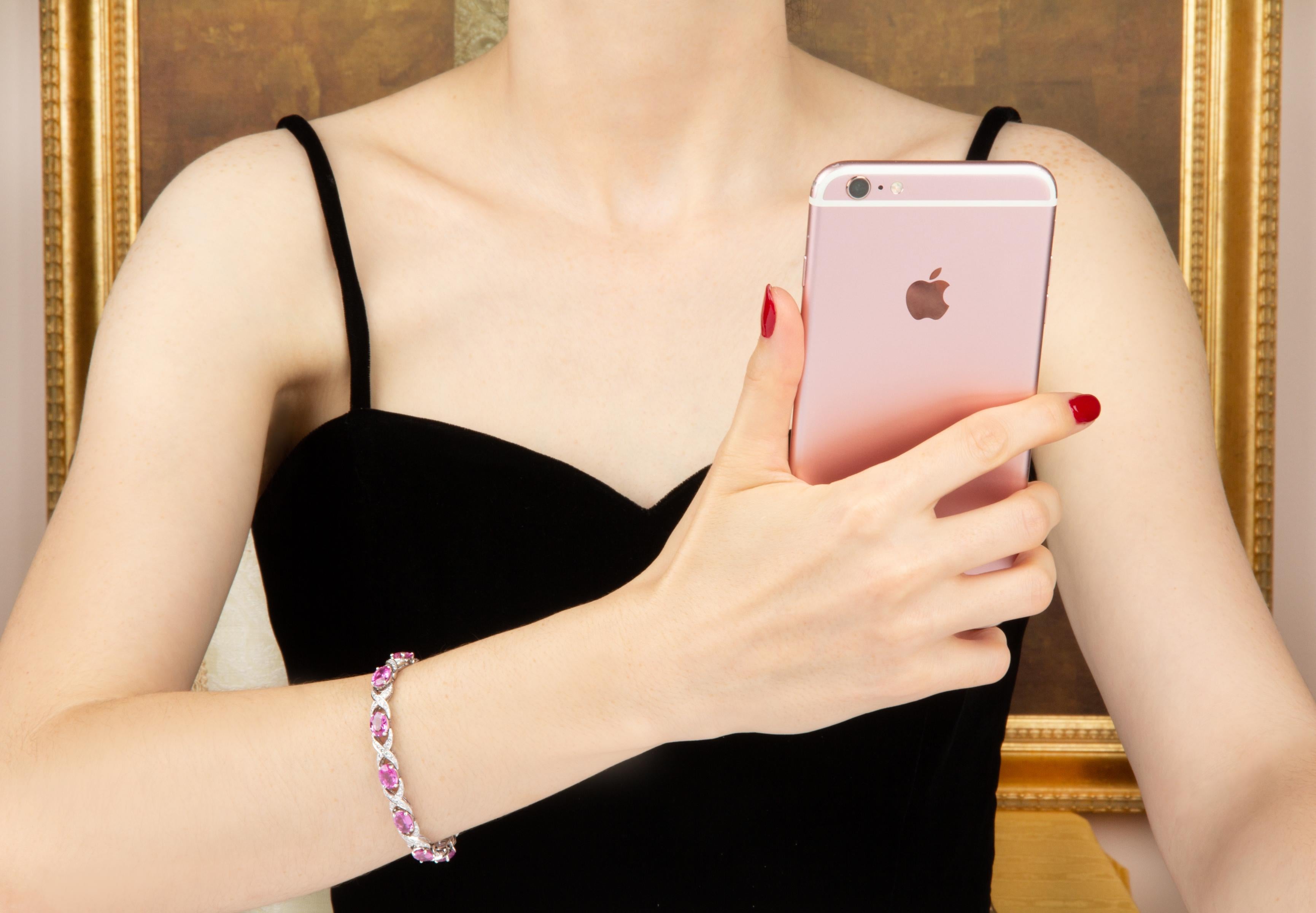 The pink sapphire and diamond bracelet features oval cut faceted sapphires of brilliant hues and crystalline texture for a total of approximately 14 carats. The design is complete with 2.00 carats of top quality diamonds (F/VVS).
The bracelet was