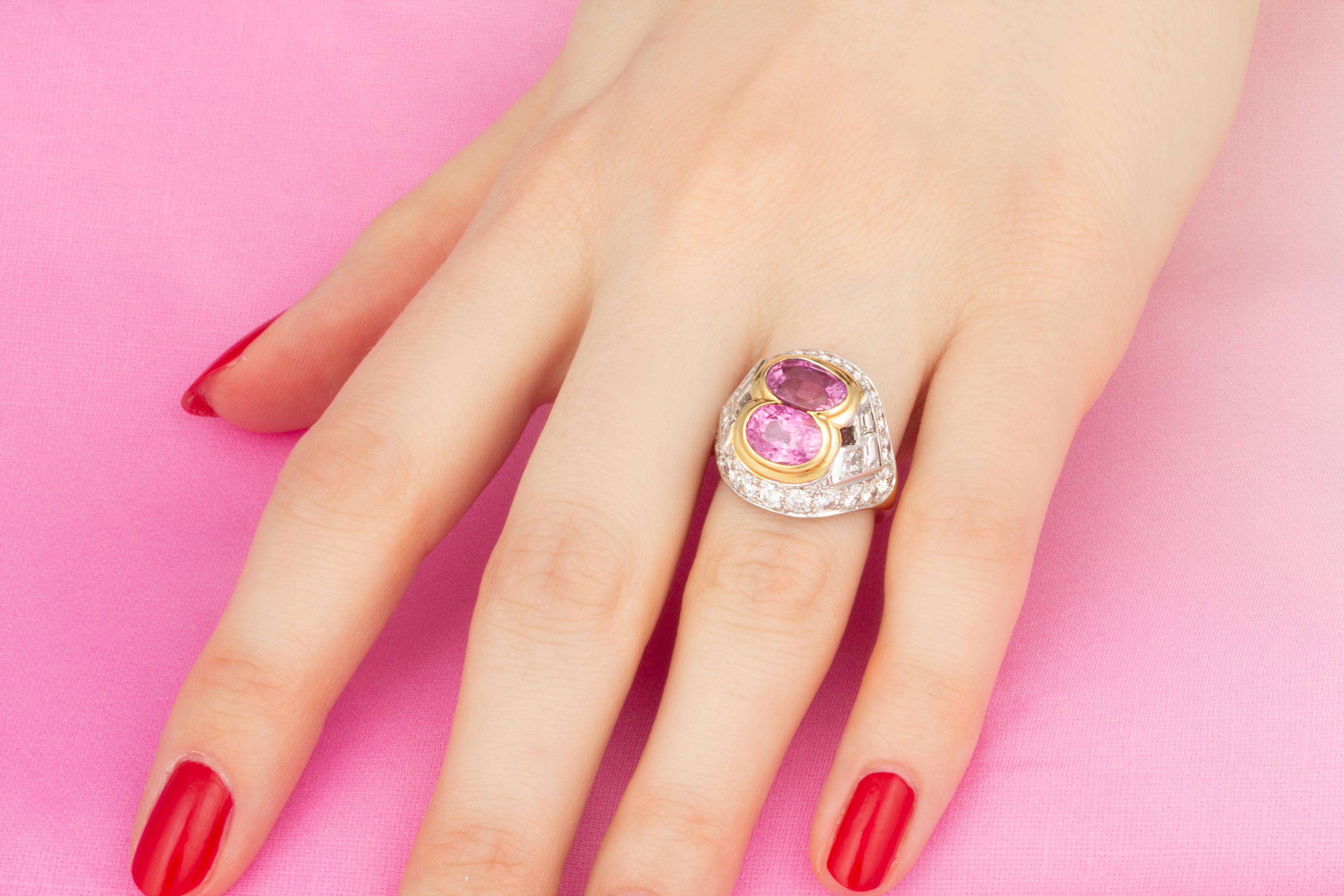 The ring features 2 faceted oval-cut pink sapphires of brilliant color (4.35 carats total) flanked by 1.80 carats of custom-cut baguette diamonds. The design is complete with 1.18 carats of round diamonds. All our diamonds are of top quality
