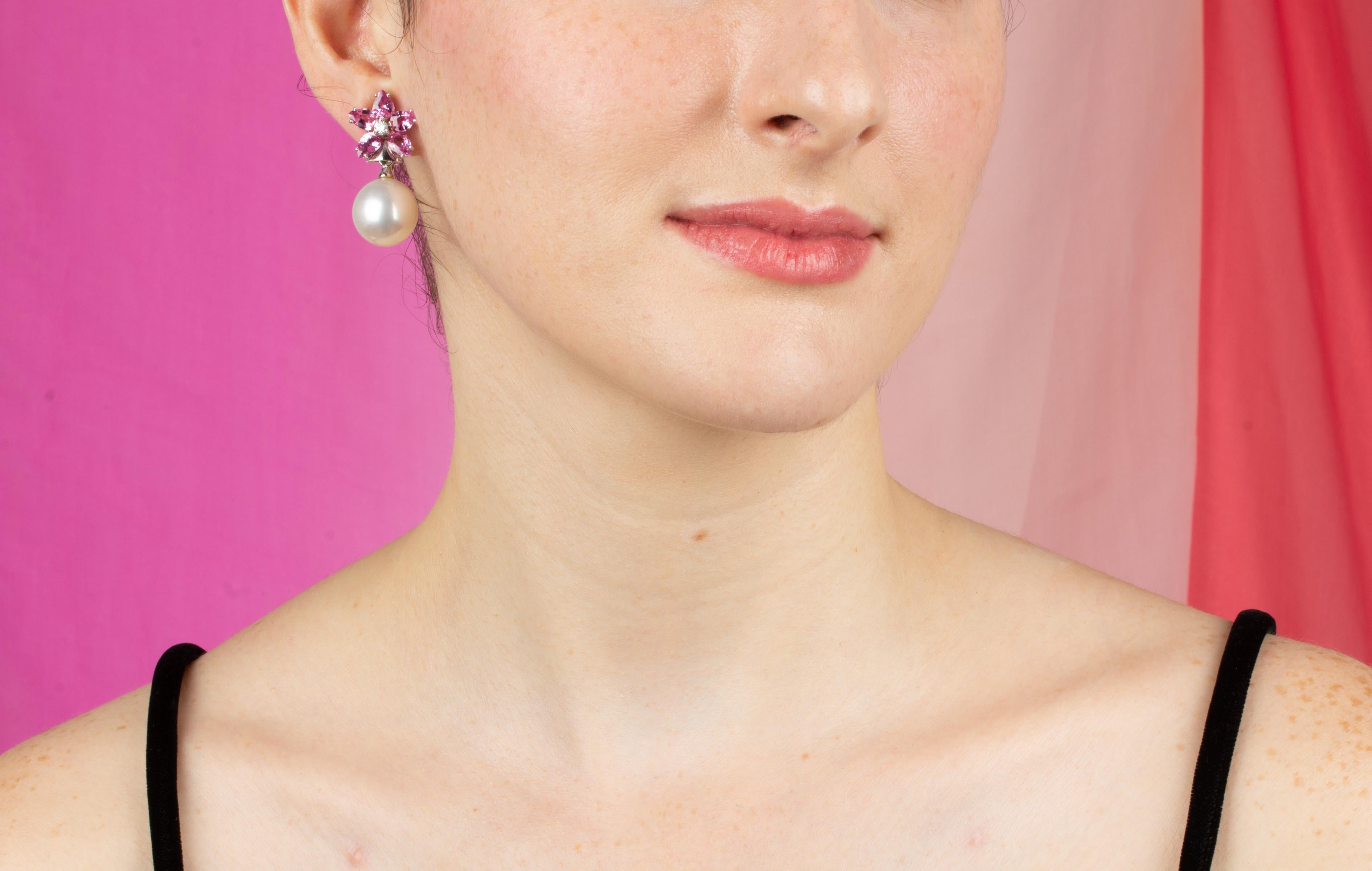 Die Ohrringe aus rosa Saphiren und Diamanten sind mit einem Blumenmuster am Ohr versehen und bestehen aus 8,82 Karat tropfenförmigen Saphiren. An den Spitzen hängen 2 Südseeperlen von 16 x 15 mm Durchmesser. 0.26 Karat runde Diamanten