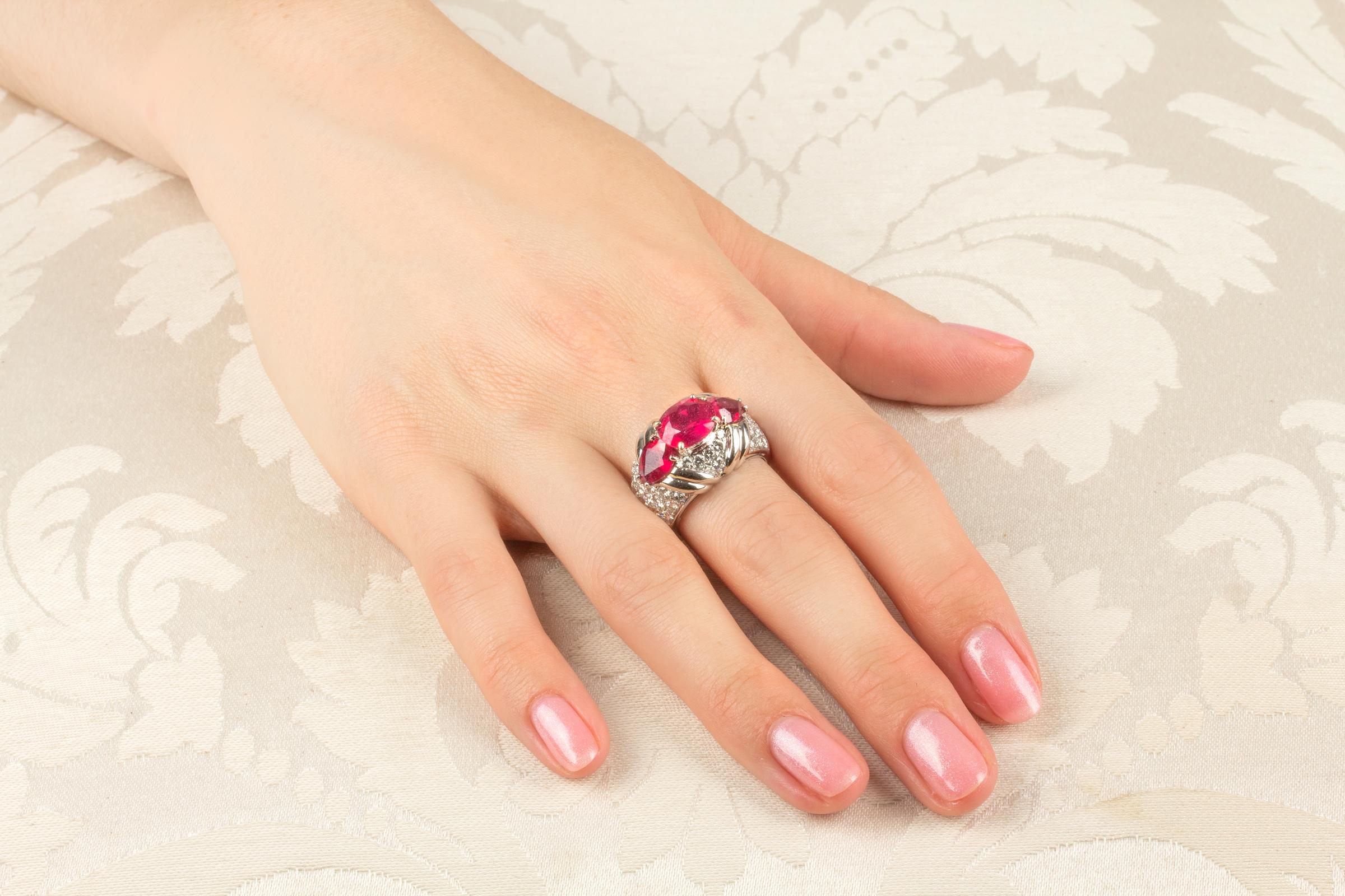 This ruby and diamond cocktail ring features 3 faceted oval-cut rubies (4.29 carats total) in a design of pavé set round diamonds (1.79 carats) with white gold accents. The diamonds are of top quality (color, clarity and cut). 
The ring is