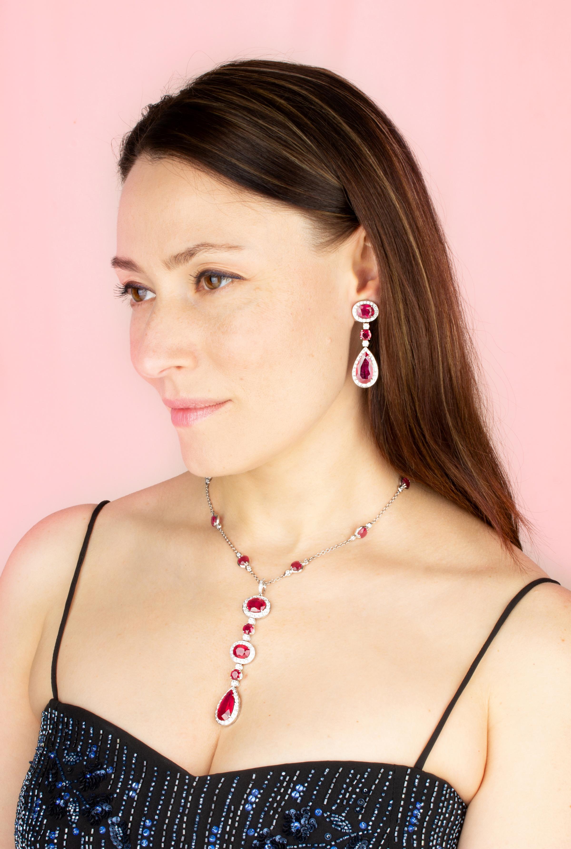 
L'ensemble collier et boucles d'oreilles rubis et diamants est constitué de rubis facettés de qualité homogène et brillante, spécialement taillés dans des diamants plus grands et plus chauds.  Mozambique à l'état brut pour obtenir les tailles