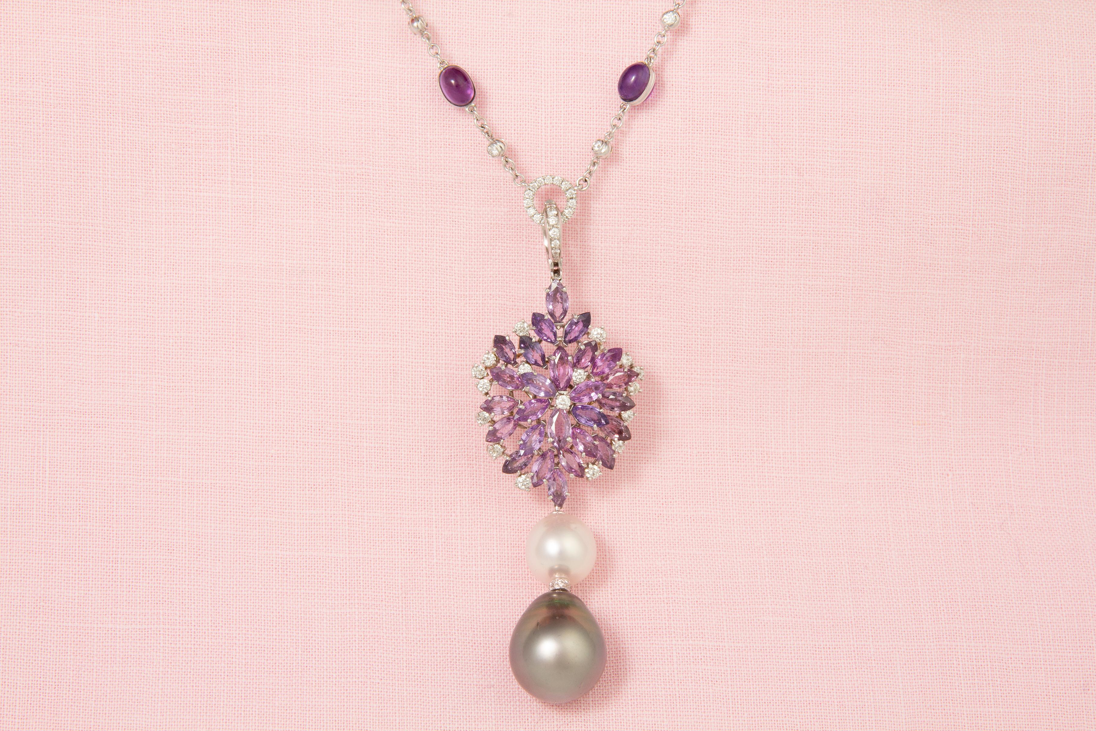 The lavender sapphire and diamond necklace features a spray of marquise shape faceted sapphires spangled with a crown of round diamonds. The jewel suspends an intermediary South Sea pearl and a Tahitian pearl of the rare size of 19 x 16mm. The 3.25”