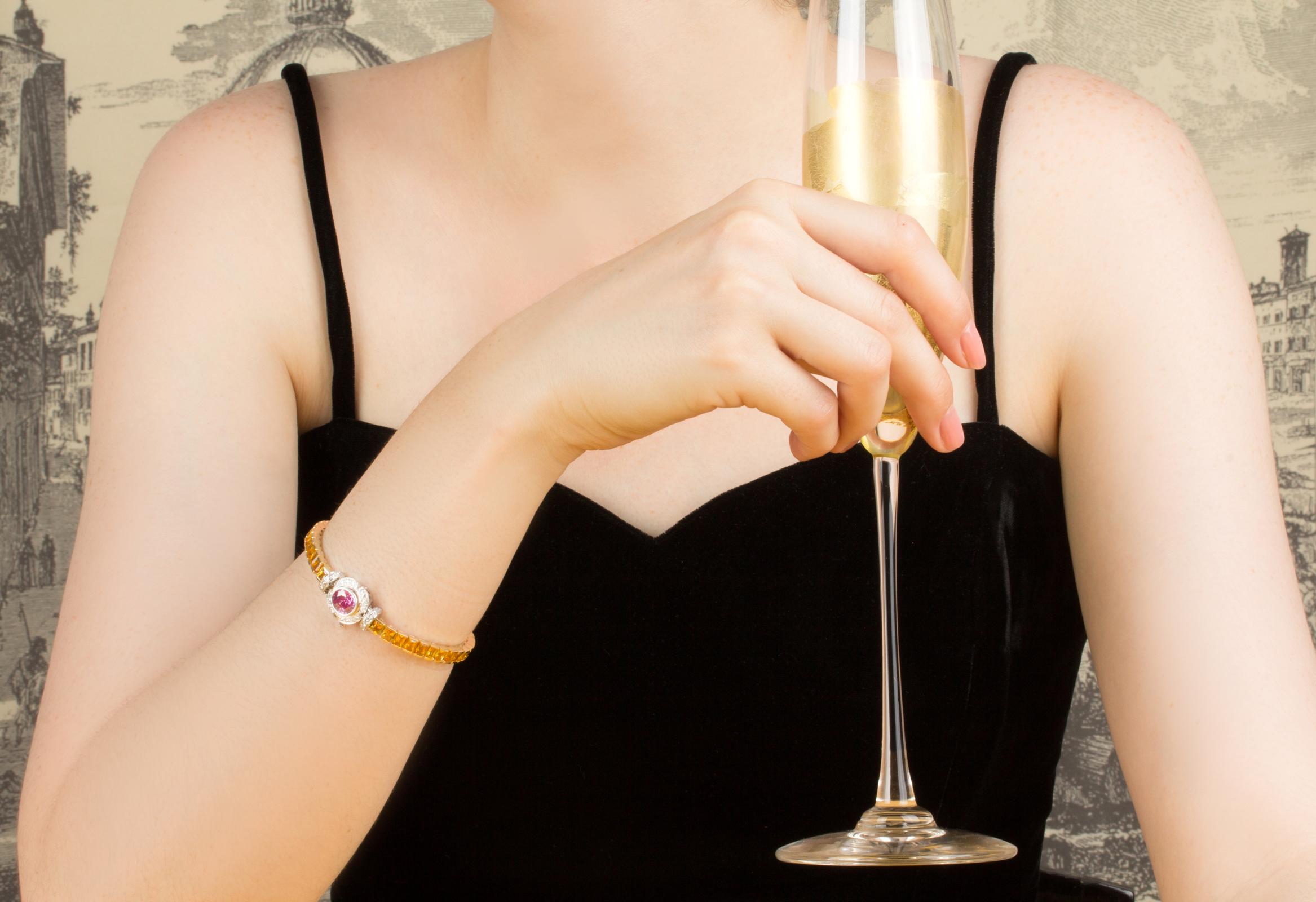 Das Armband mit Saphiren und Diamanten besteht aus einer Reihe gelber Saphire im Prinzess-Schliff (12 Karat), die von einer mit runden Diamanten besetzten Brücke flankiert werden. Die Schließe besteht aus einem ovalen, facettierten rosa Saphir (2,04