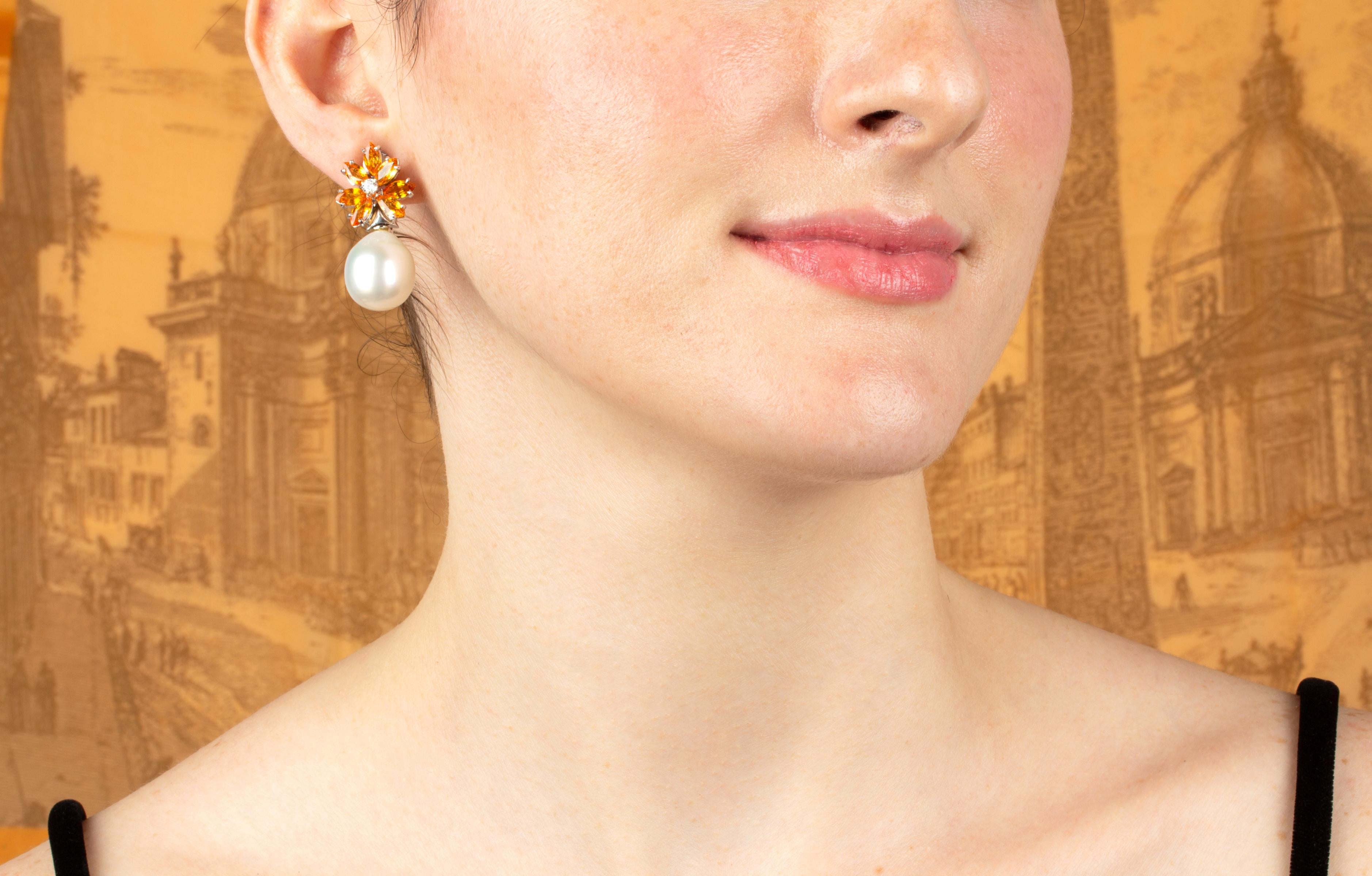 Die Saphir-Ohrringe haben ein Cluster-Design am Ohr mit 6,90 Karat orangefarbenen Saphiren im Marquiseschliff, die mit 2 Diamanten in der Mitte akzentuiert sind. An den Spitzen hängen 2 Südseeperlen von 16,5 x 14,5 mm
Alle unsere Perlen sind