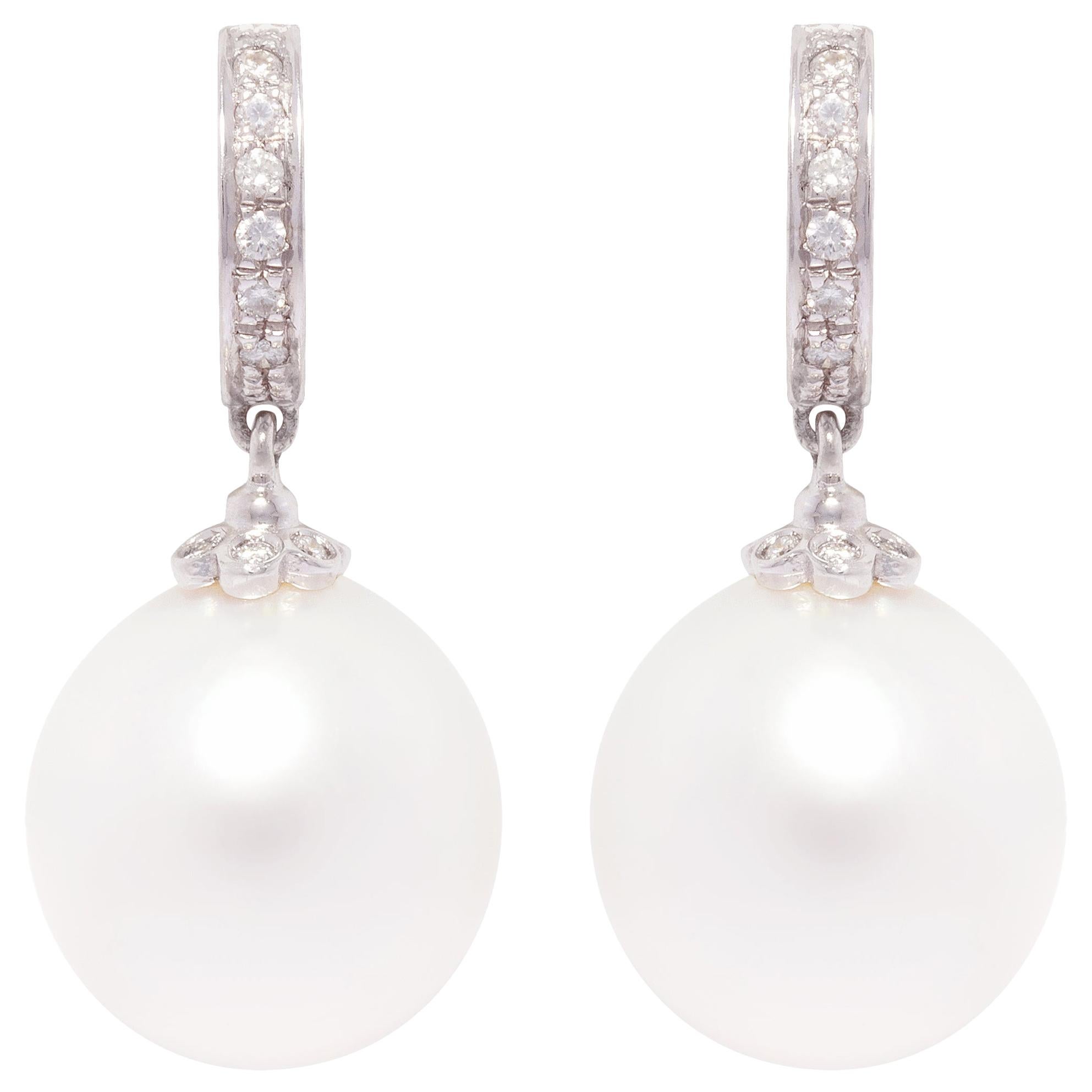The South Sea pearl and diamond drop earrings feature two 13 x 13.5 mm pearls of fine quality nacre and beautiful lustre.
The pearls are suspended from 2 hoops set with round diamonds of top quality (color, clarity and cut). The total weight of