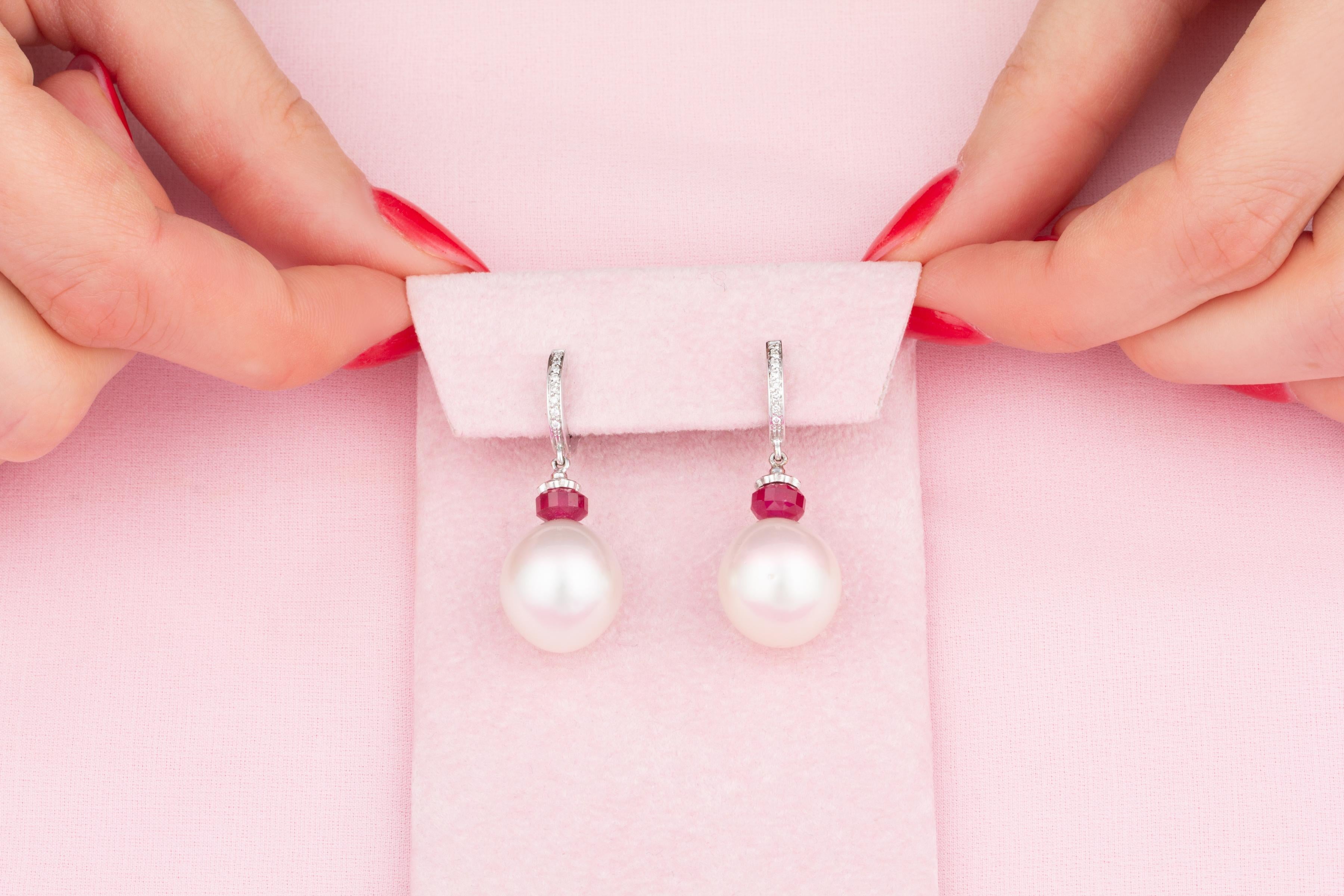 The South Sea pearl and diamond drop earrings feature two 15.5 x 14mm pearls of fine quality nacre and beautiful lustre.
The pearls are suspended from 2 hoops set with round diamonds of top quality (F/G-VVS1), via 2 decorative faceted ruby rings.