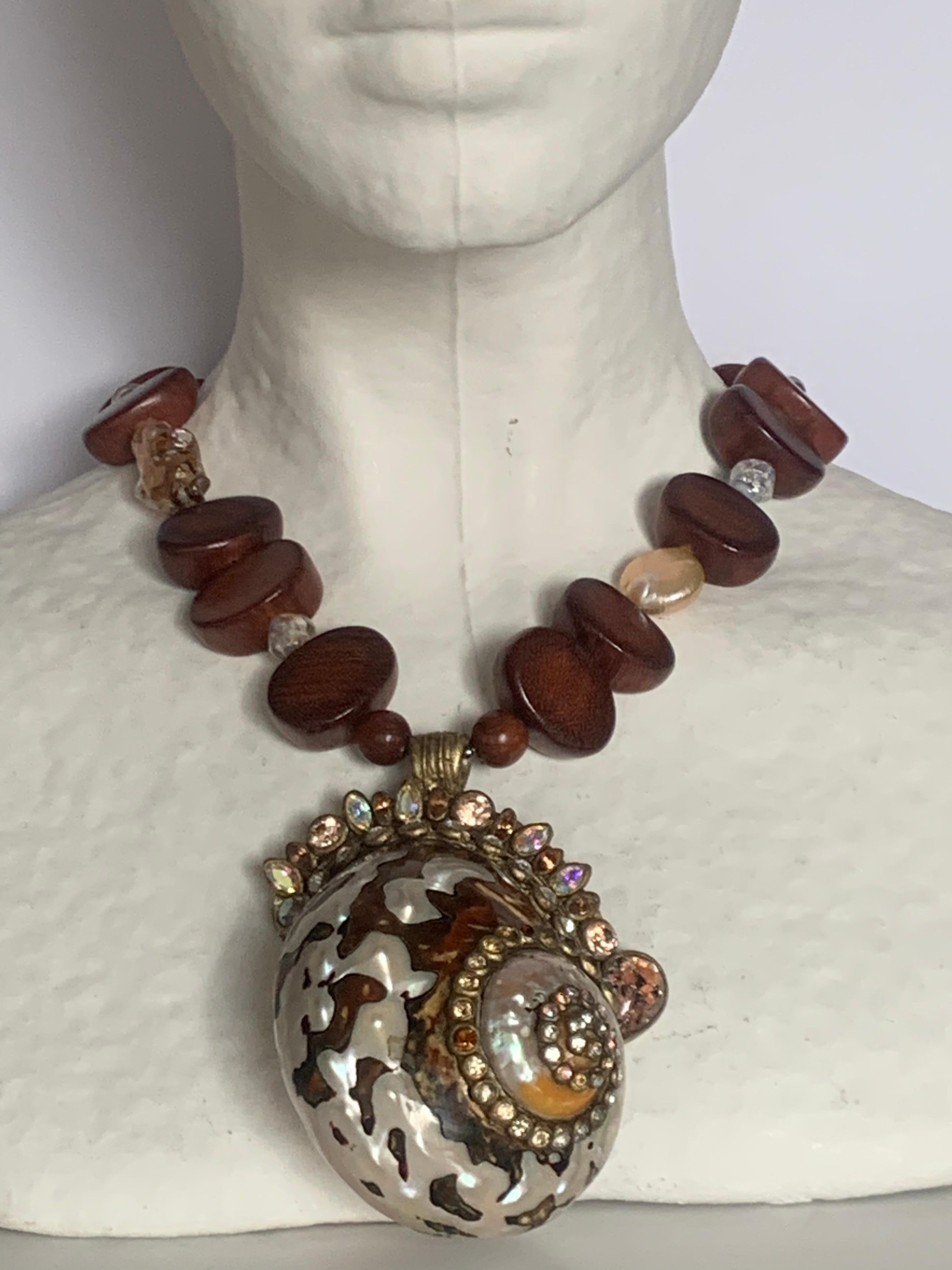 Wood bead and coin pearl necklace with extraordinary shell pendant set in paper mache with crystal elements surrounding. A true work of art. 