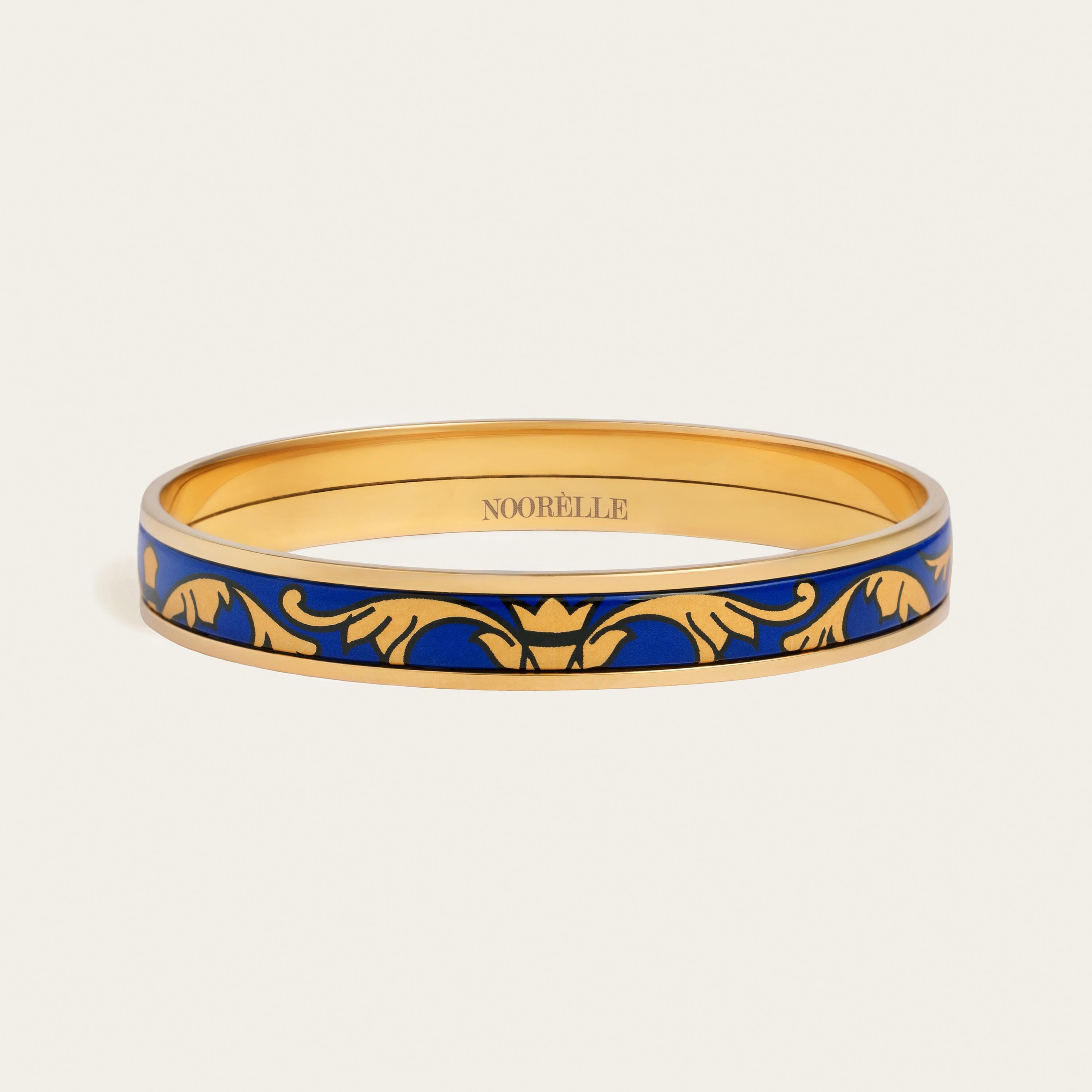 Presenting our Elle Bangle Miss. Elevate your style with our exquisite 18k gold-plated stainless steel bangle. Hand-painted with genuine fire enamel in vivid colors that will last forever, this luxurious piece is designed to make a statement.