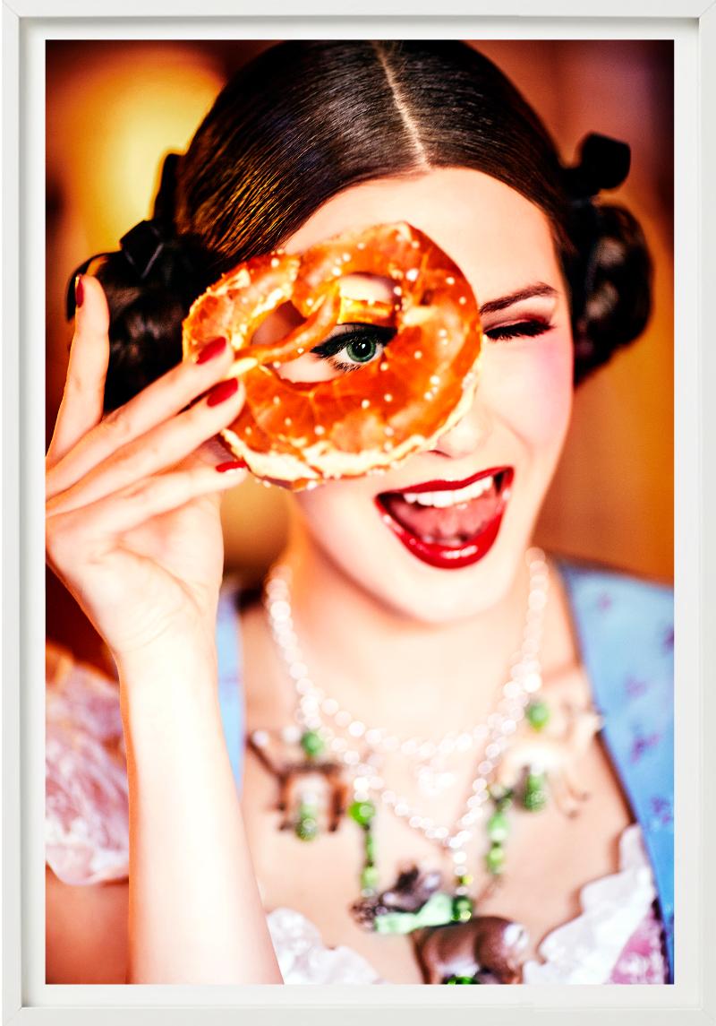 Brezel - Ragazza in Dirndl che guarda attraverso un Brezel, Fotografia Fine Arts, 2015 - Photograph di Ellen von Unwerth