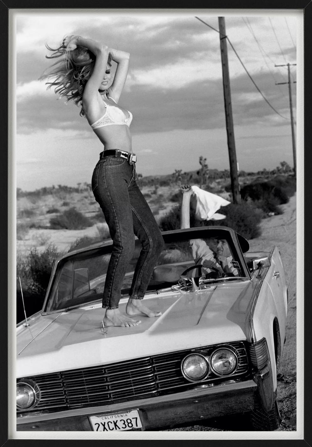 Claudia Schiffer in jeans and bra, standing on a car. Photographed by Ellen von Unwerth for the 'Guess Who' Campaign in 1989.

All prints are limited edition. Available in multiple sizes. High-end framing on request.

All prints are done and signed