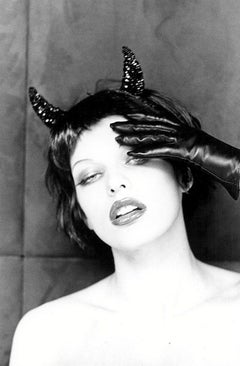 Milla Jovovich - the actress with devil horns and hand with gloves in b&w