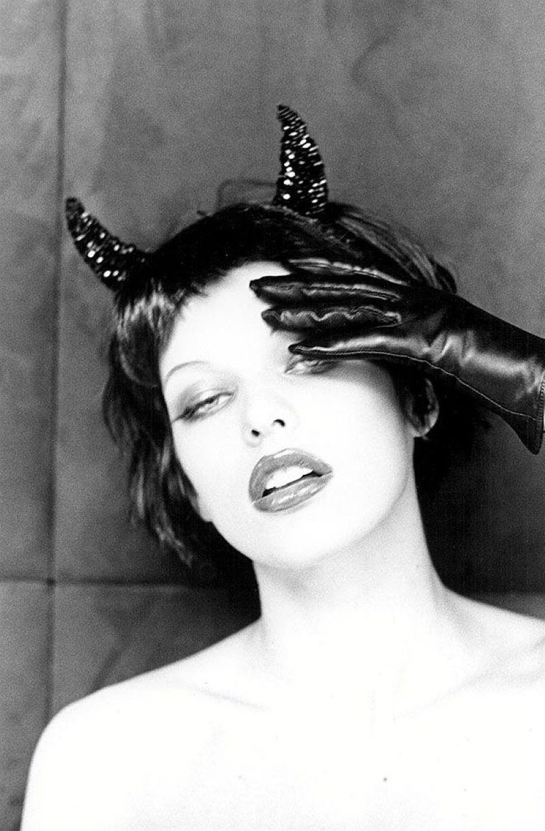 Ellen von Unwerth Black and White Photograph - Milla Jovovich - the actress with devil horns and hand with gloves in b&w