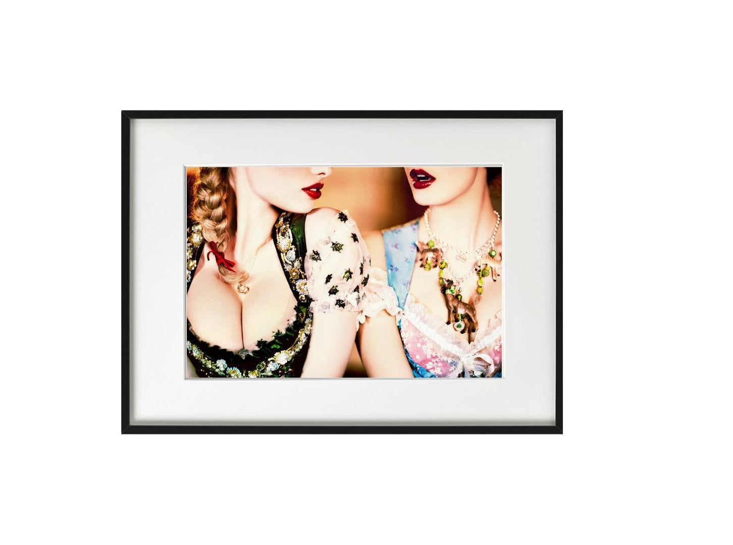 This print is available in different sizes. High-end framing on request. 

Picture of two models with red lips wearing traditional Bavarian costumes and big necklaces in the alpine mountains of Bavaria, Germany.

Ellen von Unwerth is one of the most