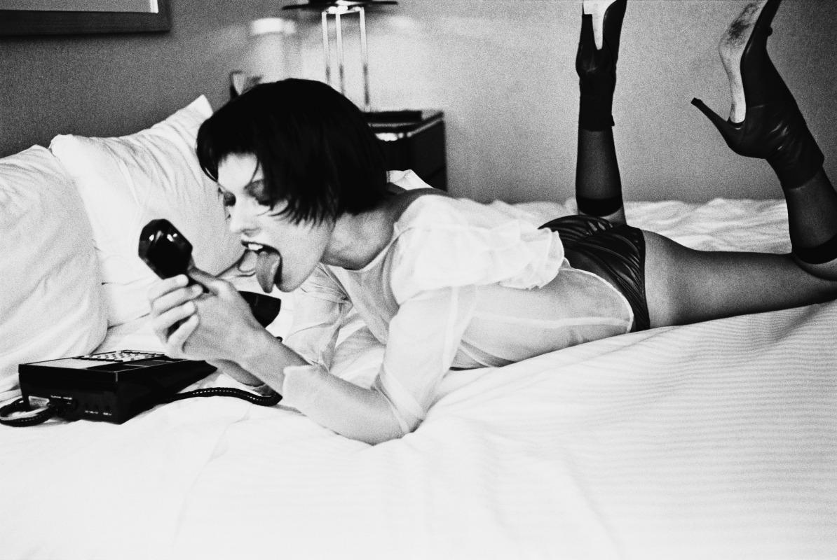 Black and White Photograph di Ellen von Unwerth - Sesso al telefono - Milla Jovovic su un letto con un telefono, Fine Art Photography, 2019