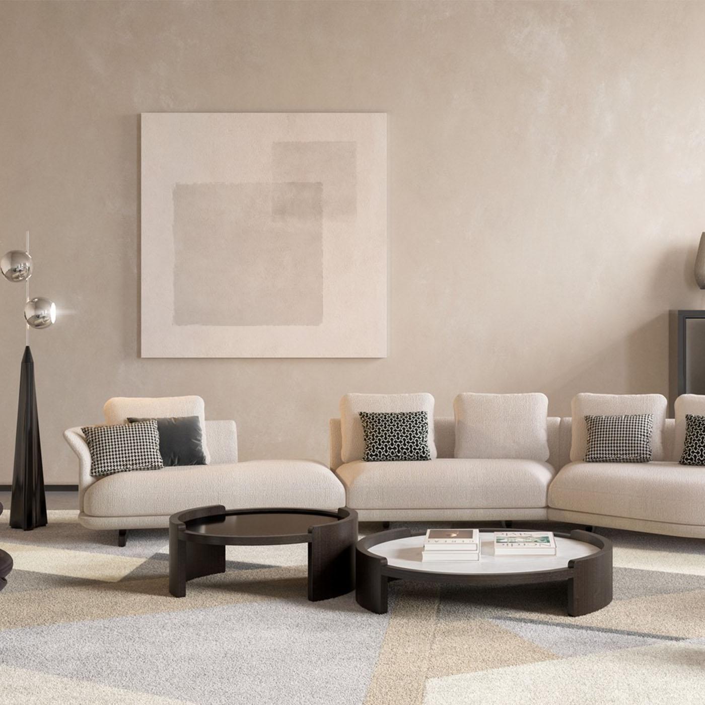 La mesa de centro Ellie 120 presenta una estructura de fresno negro con un suave acabado lacado que contrasta elegantemente con su tapa de mármol blanco. Su tamaño medio y su diseño circular ofrecen una superficie estética y funcional equilibrada,