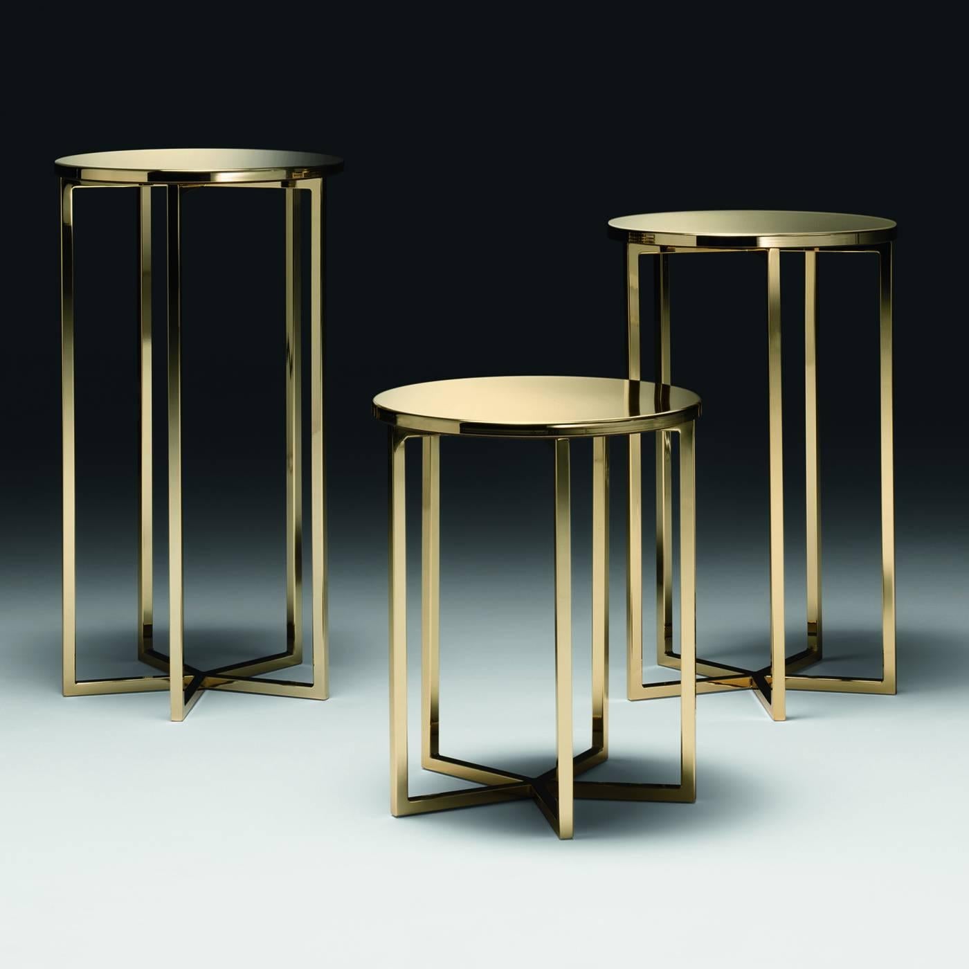 This round metal side table has a striking gold finish. The round shape of the top and the converging straight elements that support it create an elegant harmony.