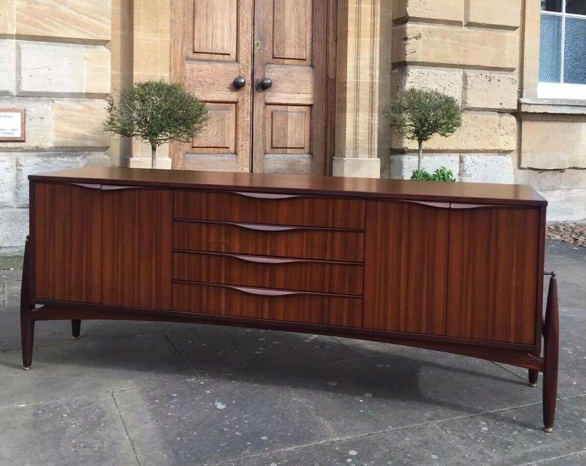 This rare 1960s sideboard is of incredible quality and design. Expertly crafted by Elliots of Newbury and made from the highest quality Zebrano teak & Comprises a middle bank of 4 drawers and cupboards either side.

Spectacular grain throughout,