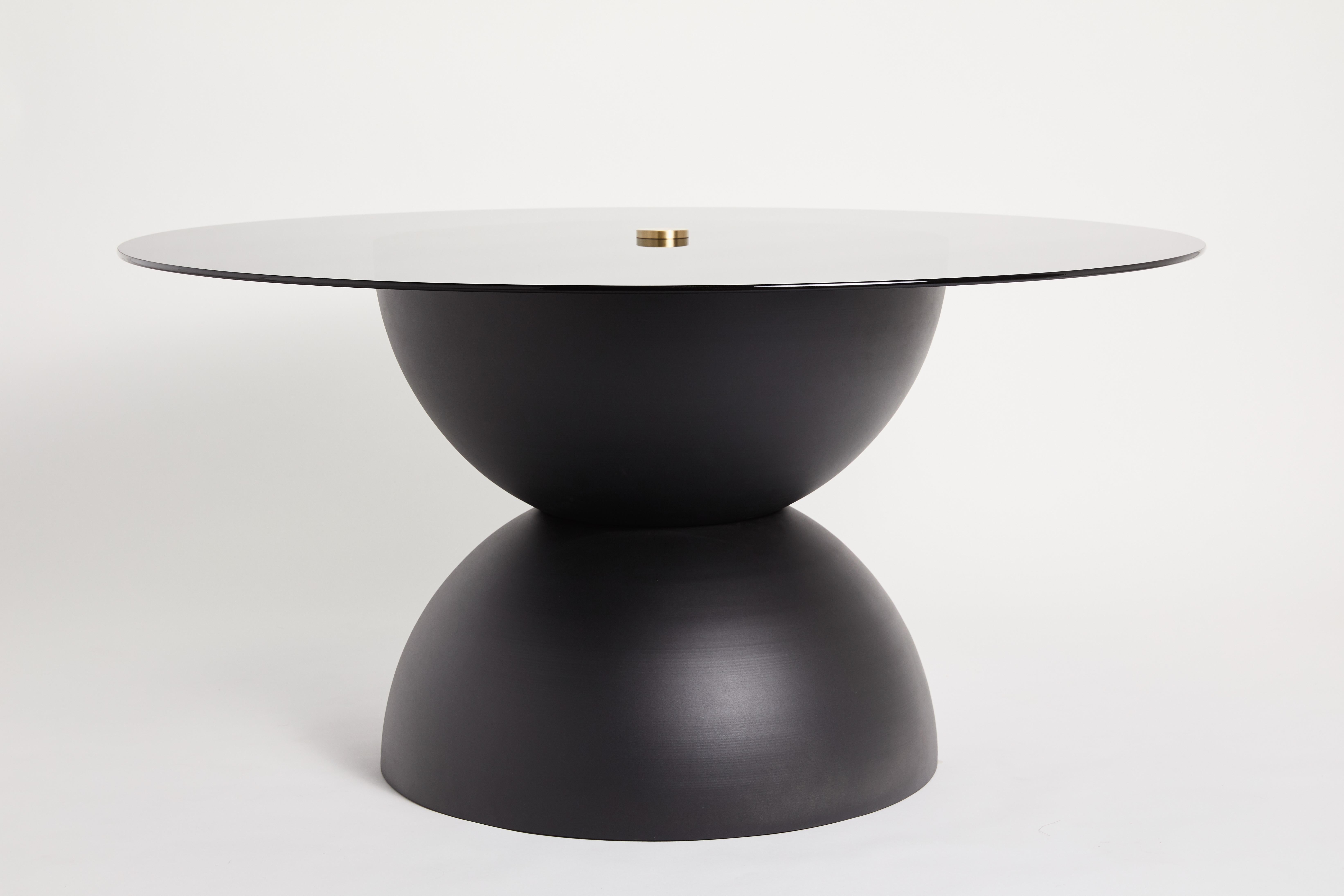 Ellipse dining table by Ben Barber Studio
Dimensions: Glass 152.4 x base 81.3 x height 73.7 cm
Materials: Aluminum, glass, brass


Two 81.3 cm aluminum hemisphere’s create a vast surface to support a circular top in glass. Aluminum powdercoat