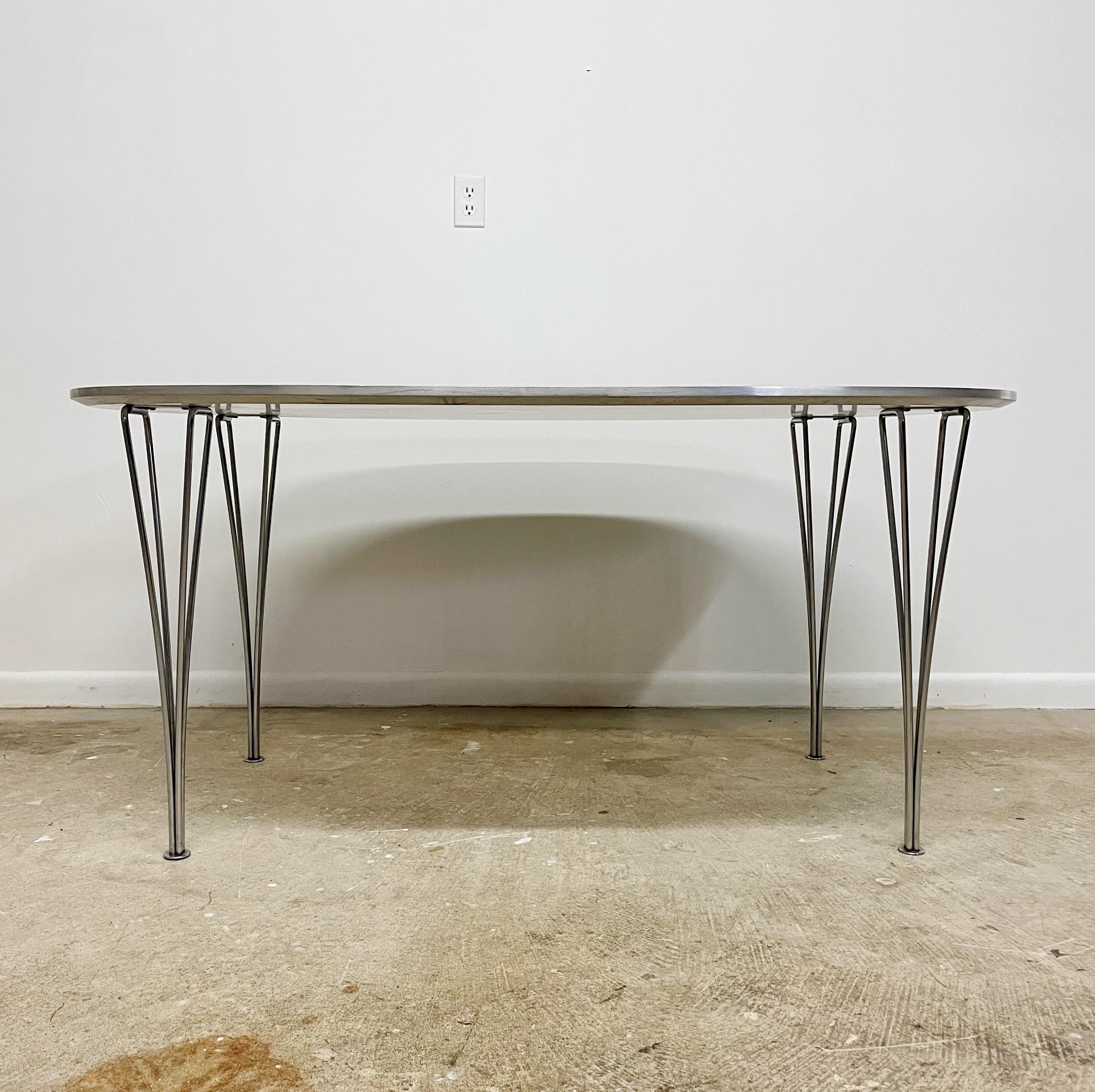 White laminate top Ellipse dining table with chrome plated steel legs by Piet Hein for Fritz Hansen with design collaboration on the table legs from Arne Jacobsen and  Bruno Mathsson.   Original Fritz Hansen, Made in Denmark, 1986 furniture makers