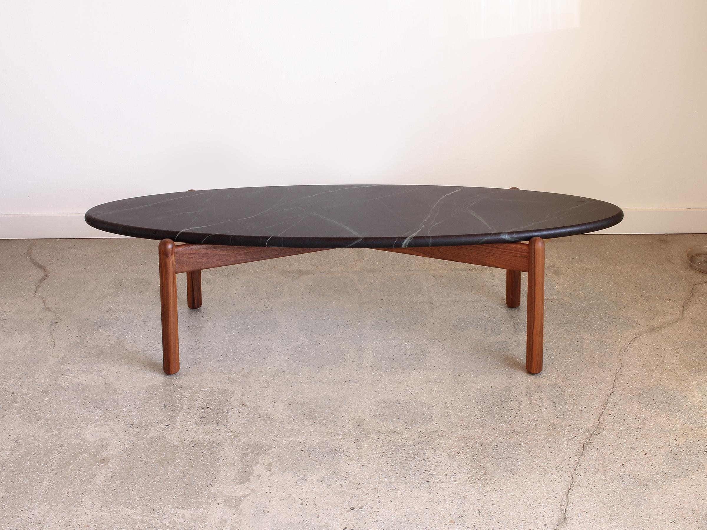 This Ellipse coffee table is made to order and shown in soapstone top with walnut base. The beauty of soapstone is evident when seen in person because of the semi translucent quality. Rich dark greens and blacks with light colored veins are the
