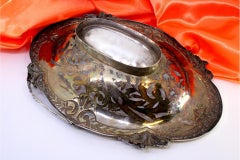 Elliptical cut silver fruit bowl with raised floral motifs and handle