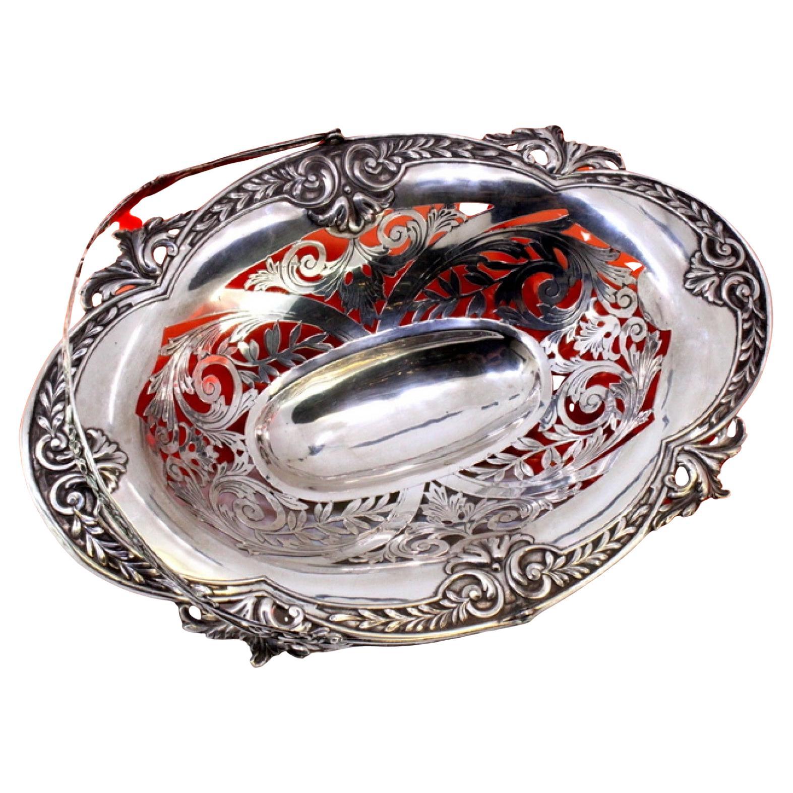 Elliptical cut silver fruit bowl with raised floral motifs and handle
