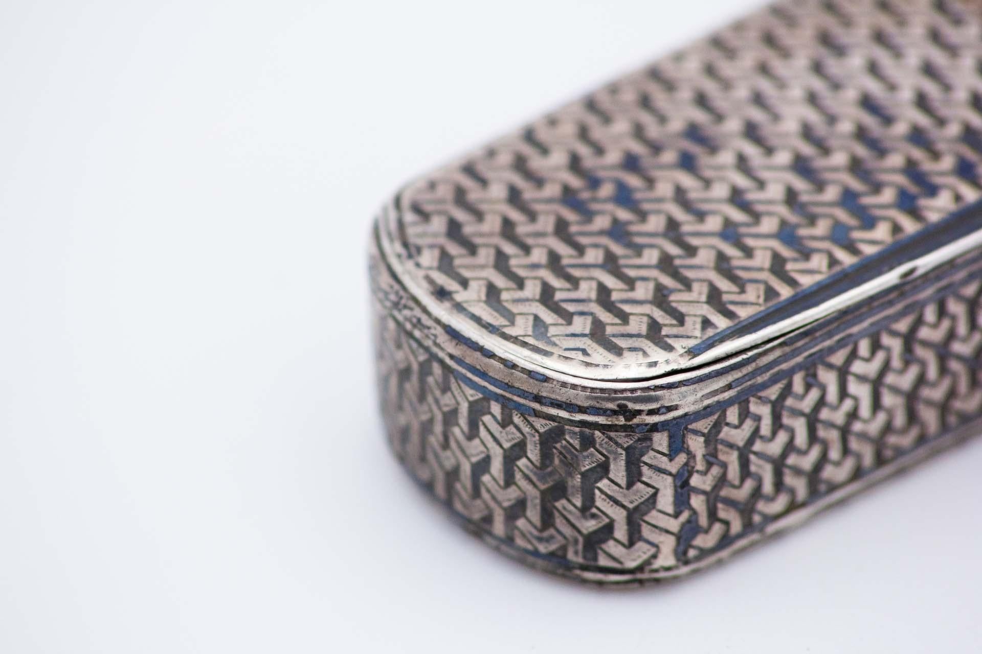 Description: Elliptical shaped nickel silver snuff box with asymmetrical reliefs, gold interior and hinged lid. Metal: Silver. Origin: French. Brand: Tête Minerve. Weight: 98.05 grams. Dimensions: 9.5cmx2cm. Content: 800/1000. Assay Mark: Yes,