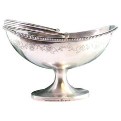 Elliptical silver candy box w/ engraved floral motifs 
a movable beaded handle