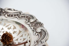 Elliptical silver fruit bowl with cut-out floral reliefs & single foot