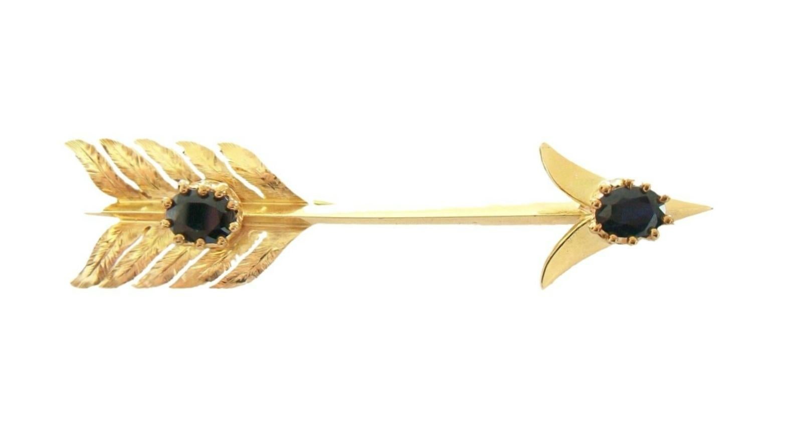 ELLIS BROS. LTD. - Antique hand-made 18K solid yellow gold arrow brooch - impressive size set with two oval cut natural black/blue Spinel (approx. .42 carats each - 5 x 4 x 3 mm.) - finely chased details to the 'feathers' - hand-made double pin and