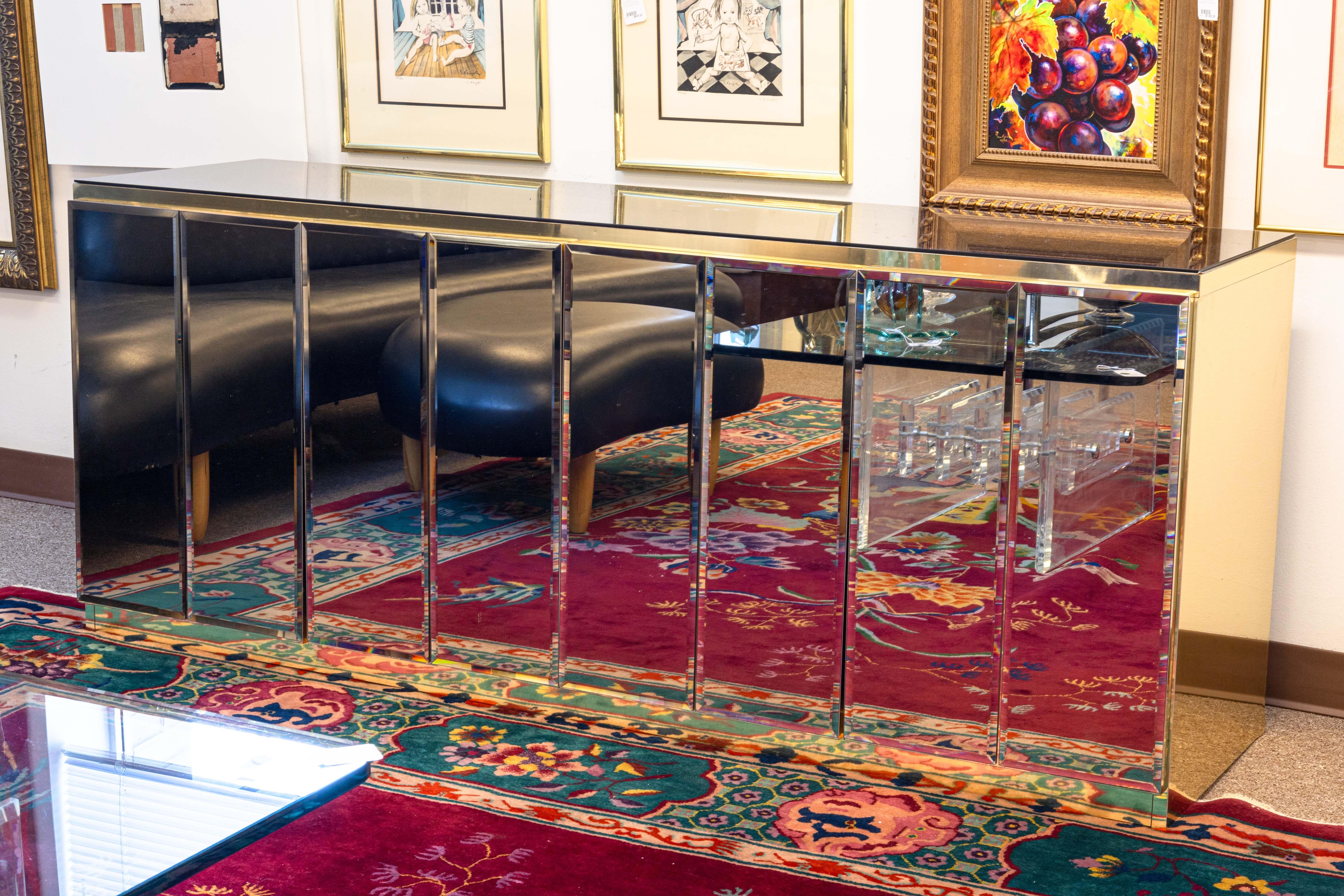 An Ello Furniture brass and beveled mirrors credenza sideboard. This is a spectacular piece with a bold Hollywood Regency style from Ello Furniture, designed by O.B. Solie. This amazing piece features head to toe reflections with its brass body