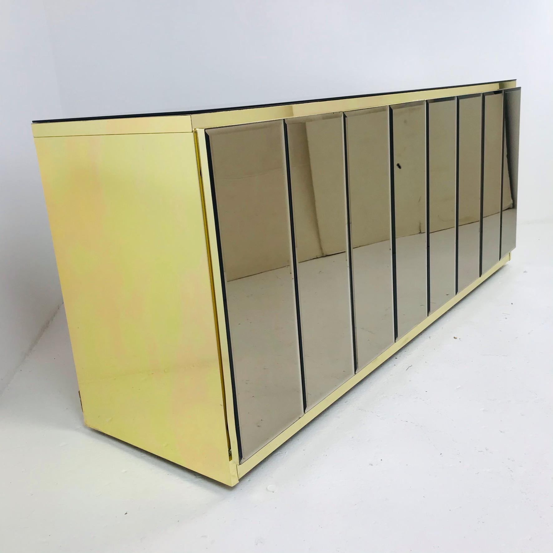 Unique 1980's sideboard/credenza by Ello. Great original condition. Glamorous and modern with brass sides and rose tint mirror front. Double cabinets in each piece.