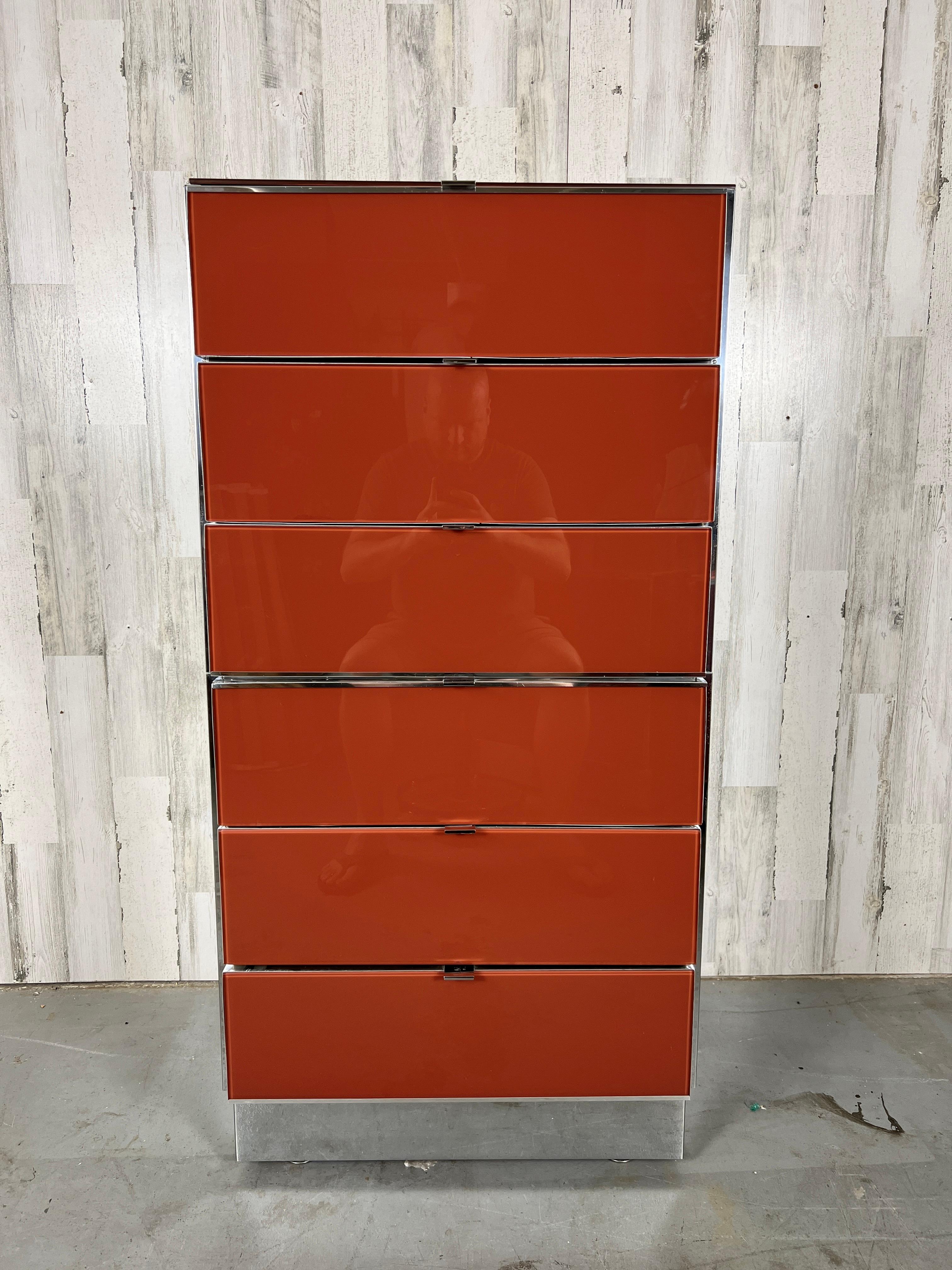 Ello Lacquered glass and chrome high boy dresser. Burnt orange lacquered glass with shiny chrome sides, trim, and handles.