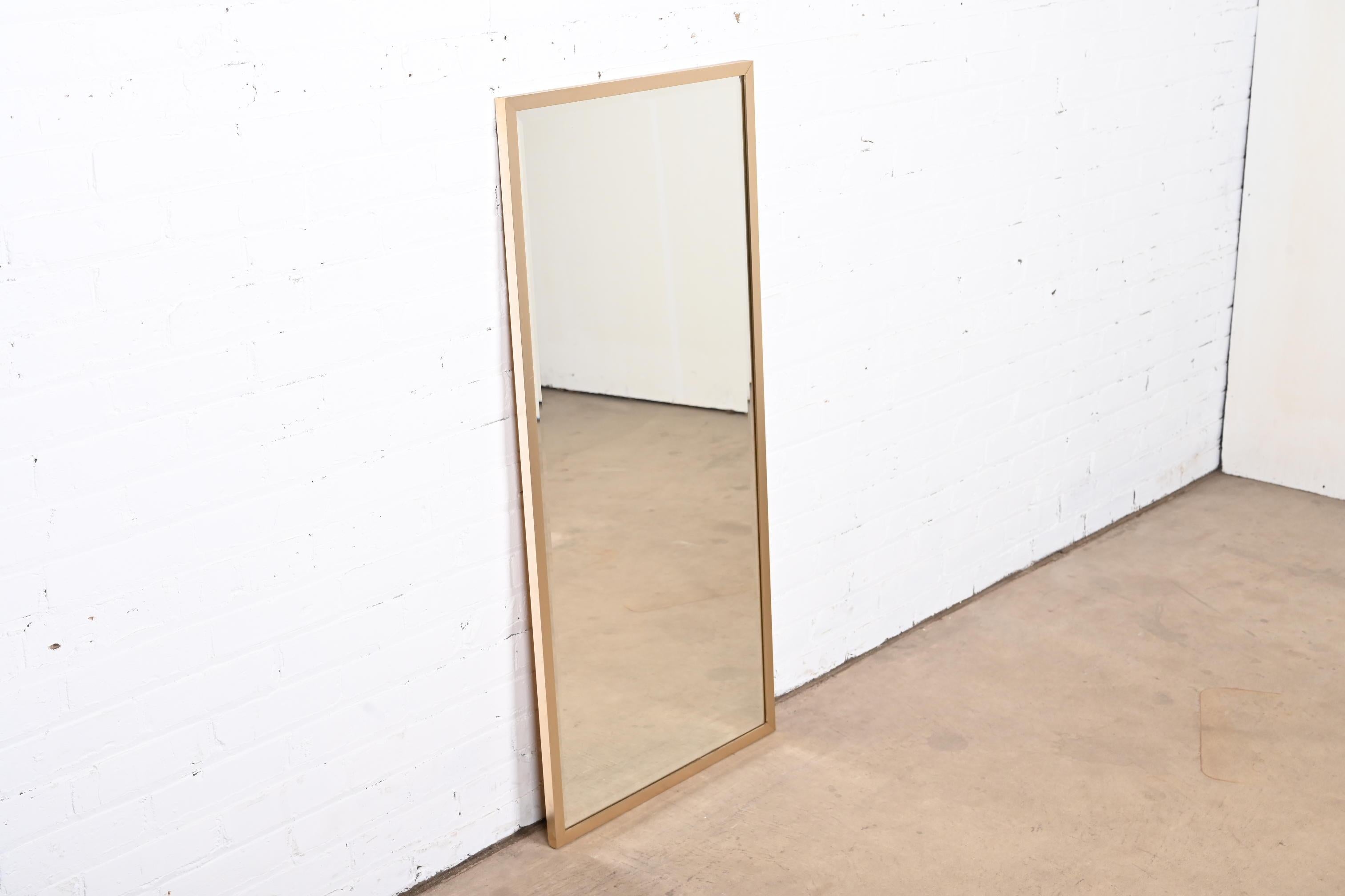 A sleek and stylish Mid-Century Modern brass finish framed tall beveled wall mirror

By Ello

USA, Circa 1970s

Measures: 21