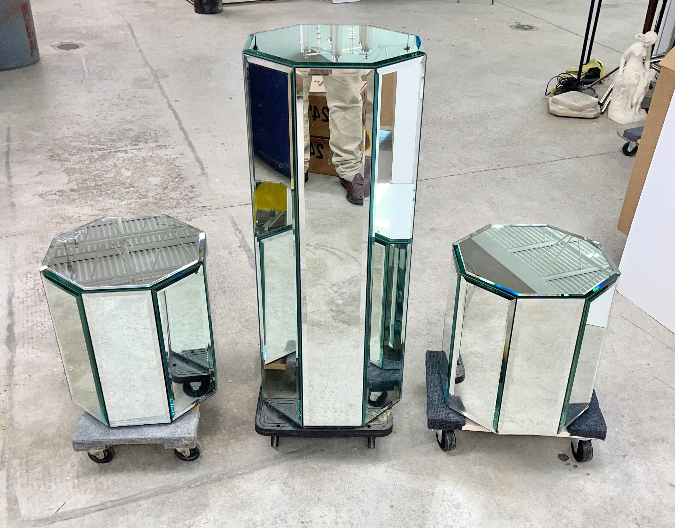 Set of three octagonal form pedestal column display stands paneled in beveled mirrored glass designed by O. B. Solie for Ello Furniture Manufacturing Co. of Rockford, IL.
Each is 15 inches diameter.
The tall one is 36.5 inches high.
The pair of