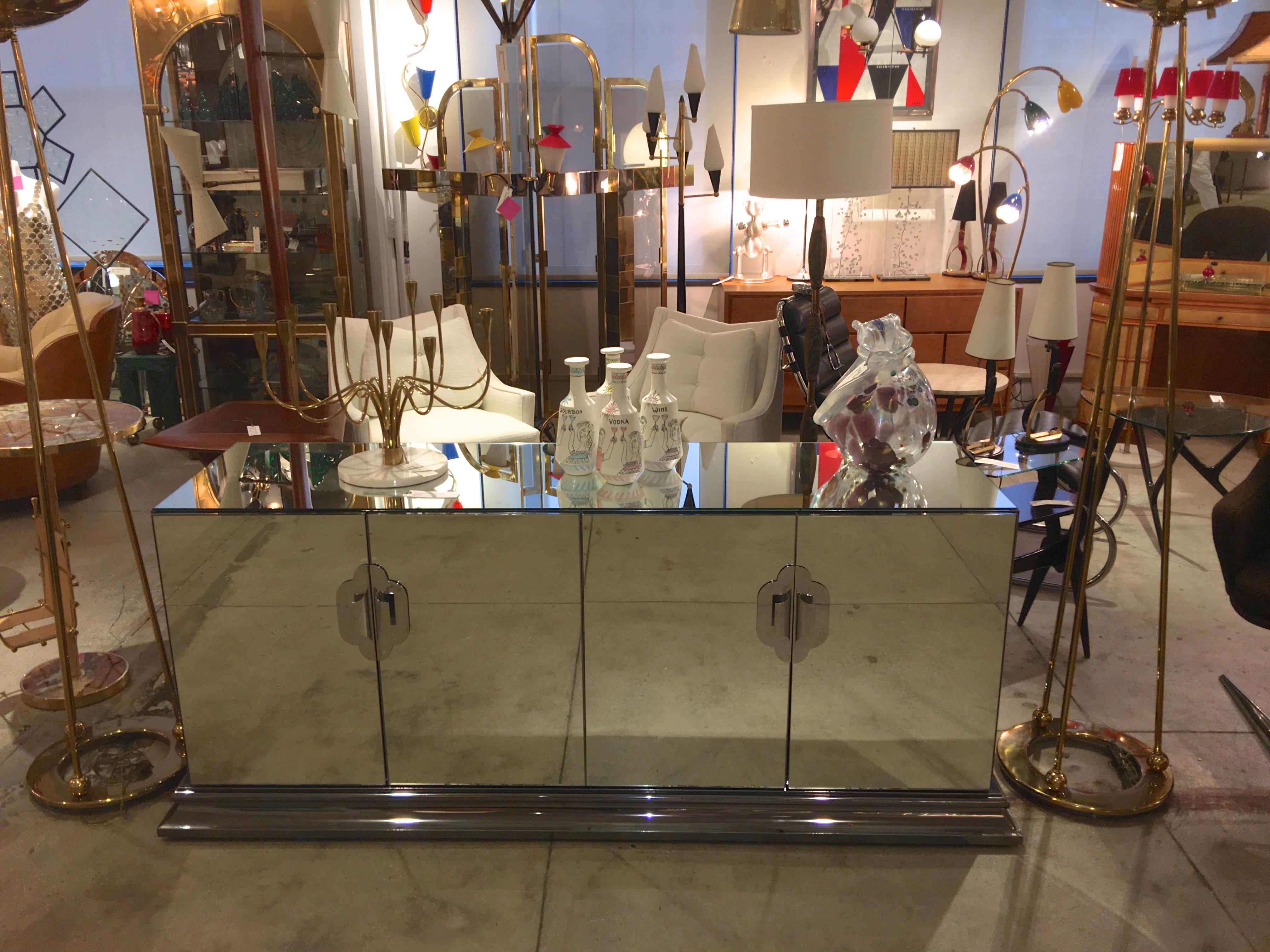 Luxuriously well constructed mirrored sideboard cabinet on heavy molded chrome plinth base produced by Ello Furniture Manufacturing Co. in the 1970s and designed by O. B. Solie. Materials used are mirror-polished stainless steel and laminated