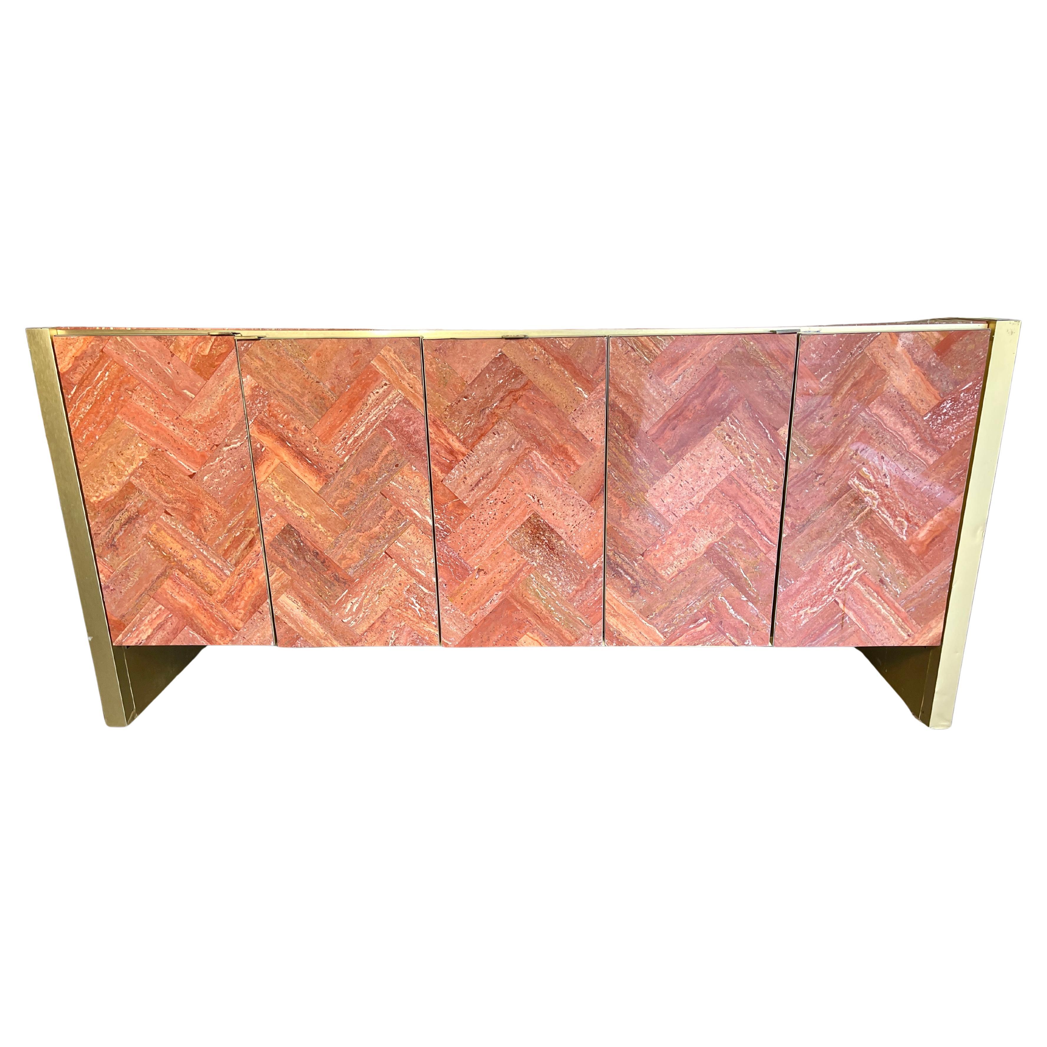 Credenza a cinque ante disegnata da O. B. Solie per Ello Furniture. Il piano e le facce delle porte sono rivestite in marmo travertino rosso persiano lucidato con un motivo a spina di pesce.  I supporti e le porte sono rifiniti in ottone spazzolato.