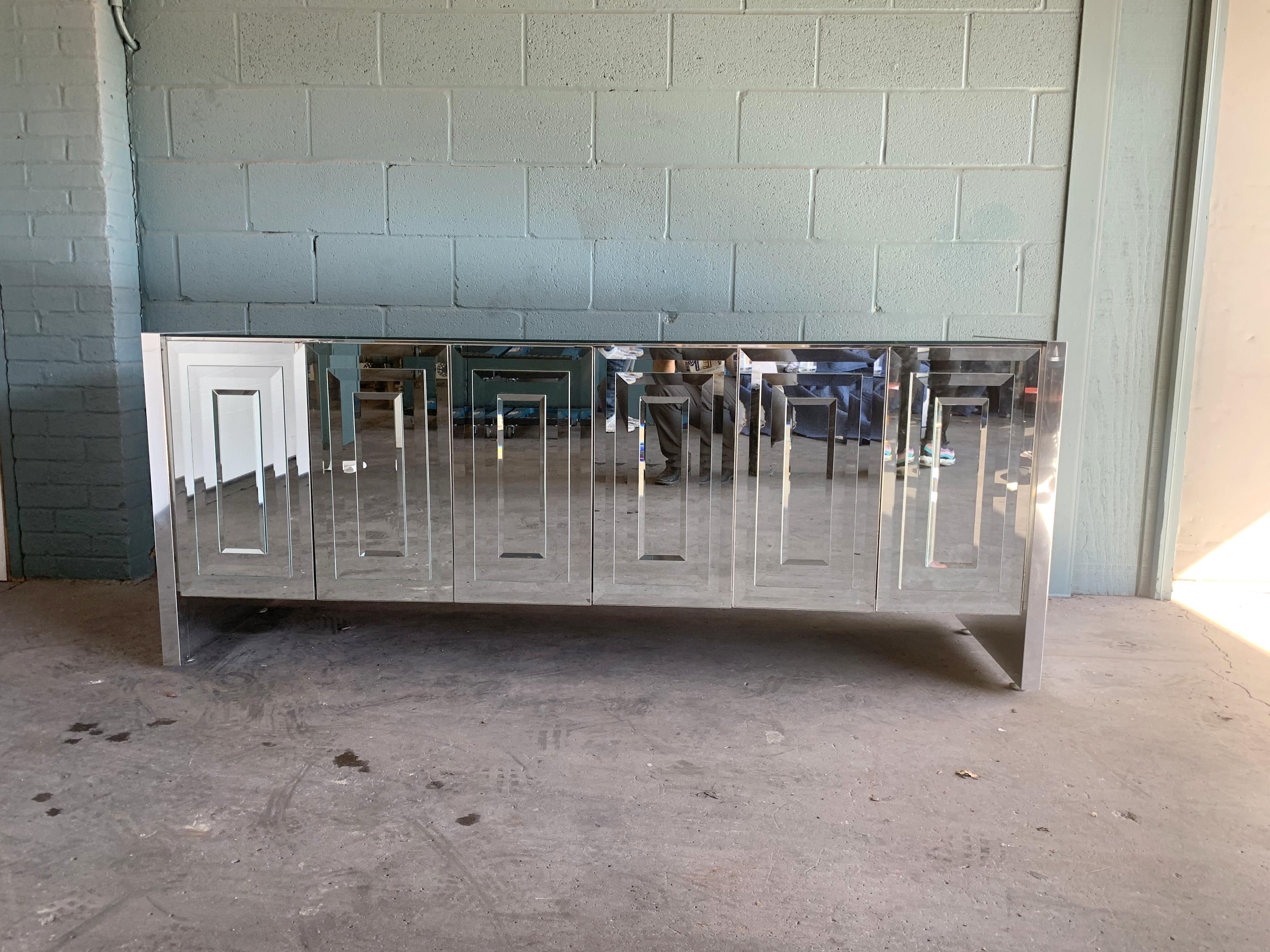 Stunning six-door mirrored and chrome cabinet by Ello.
One of the best on the web!
Other than one little dark spot (photographed), I can't find any other marks. Cabinet is mirrored and thus is reflecting the stone floor and walls.
Doors and