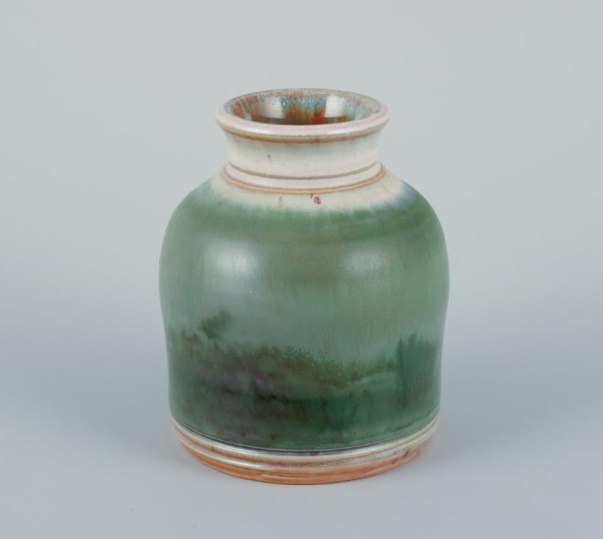 Elly Kuch (1929-2008) and Wilhelm Kuch (1925-2022). 
Two unique ceramic vases.
One vase with glaze in green tones.
The other vase with reddish glaze on a sand-colored base.
From the 1980s.
Signed.
In excellent condition. One vase with natural