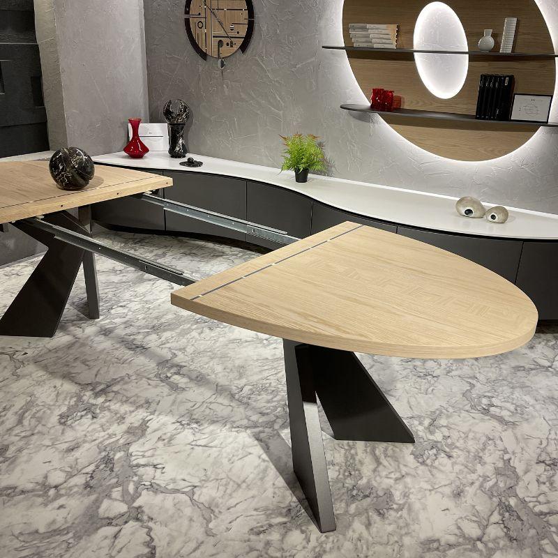 Elegant 6 to 10-seater oval dining table, with light wood top and modern X-shaped supporting structure. The elliptical shape of the top allows the placement of this important table even in small spaces. This table (closed 180 cm x 100 cm) has two