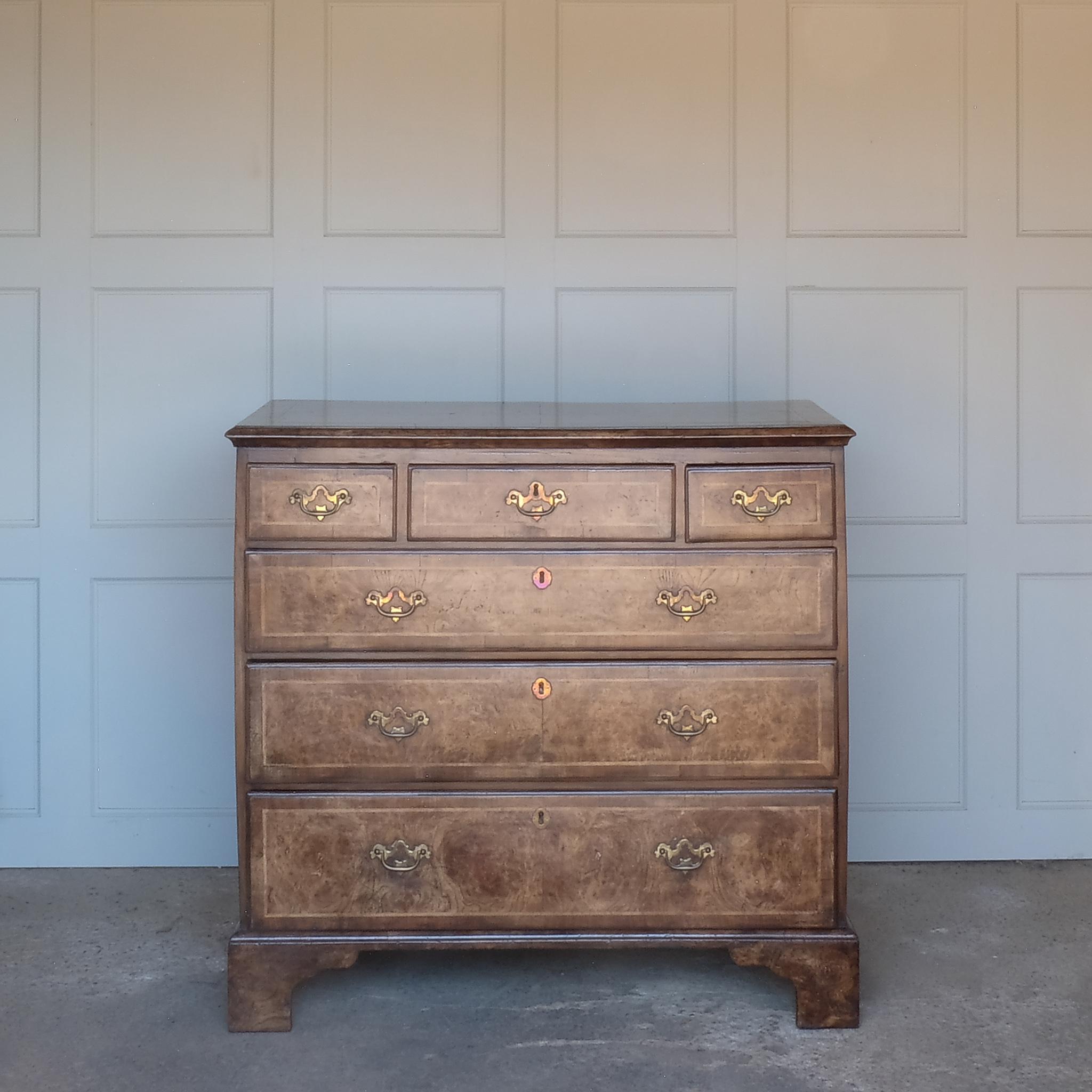 An interesting and rare elm and burr walnut crossbanded chest of drawers, dating from c. 1740, with a quarter veneered top and three short over three long drawers, raised on bracket feet. In very good condition with a beautiful historic patina